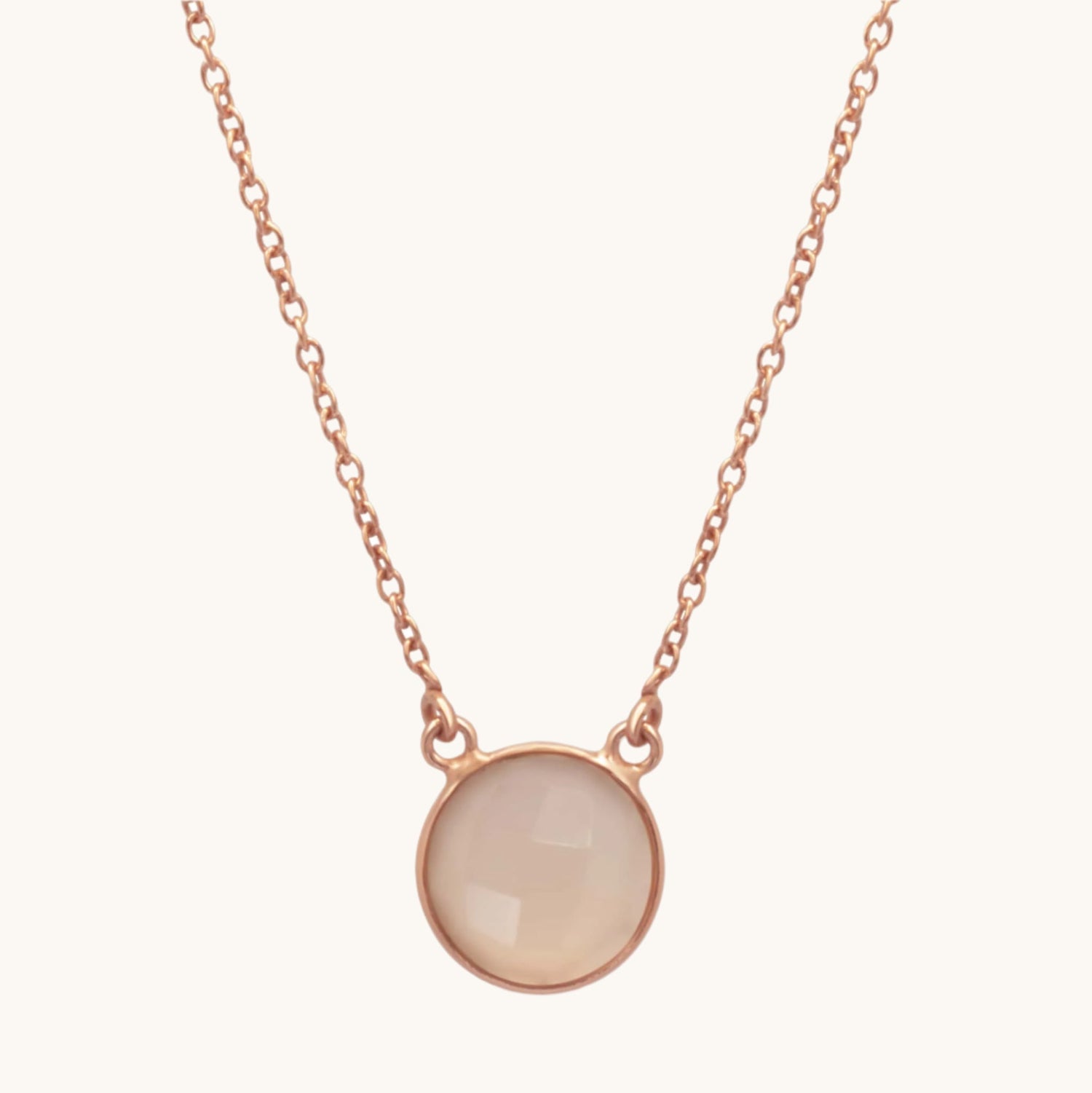Single semi-precious pink stone necklace in rose gold plated on a soft cream background