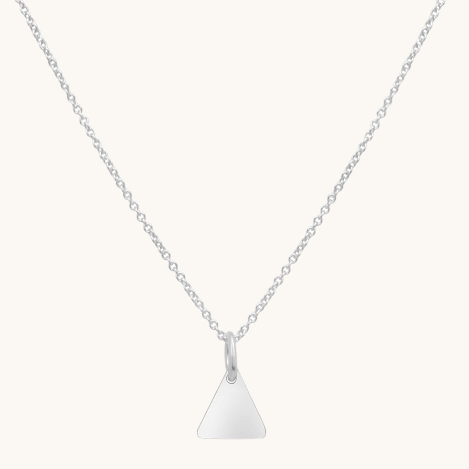 Sterling silver necklace with triangular pendant on cream background