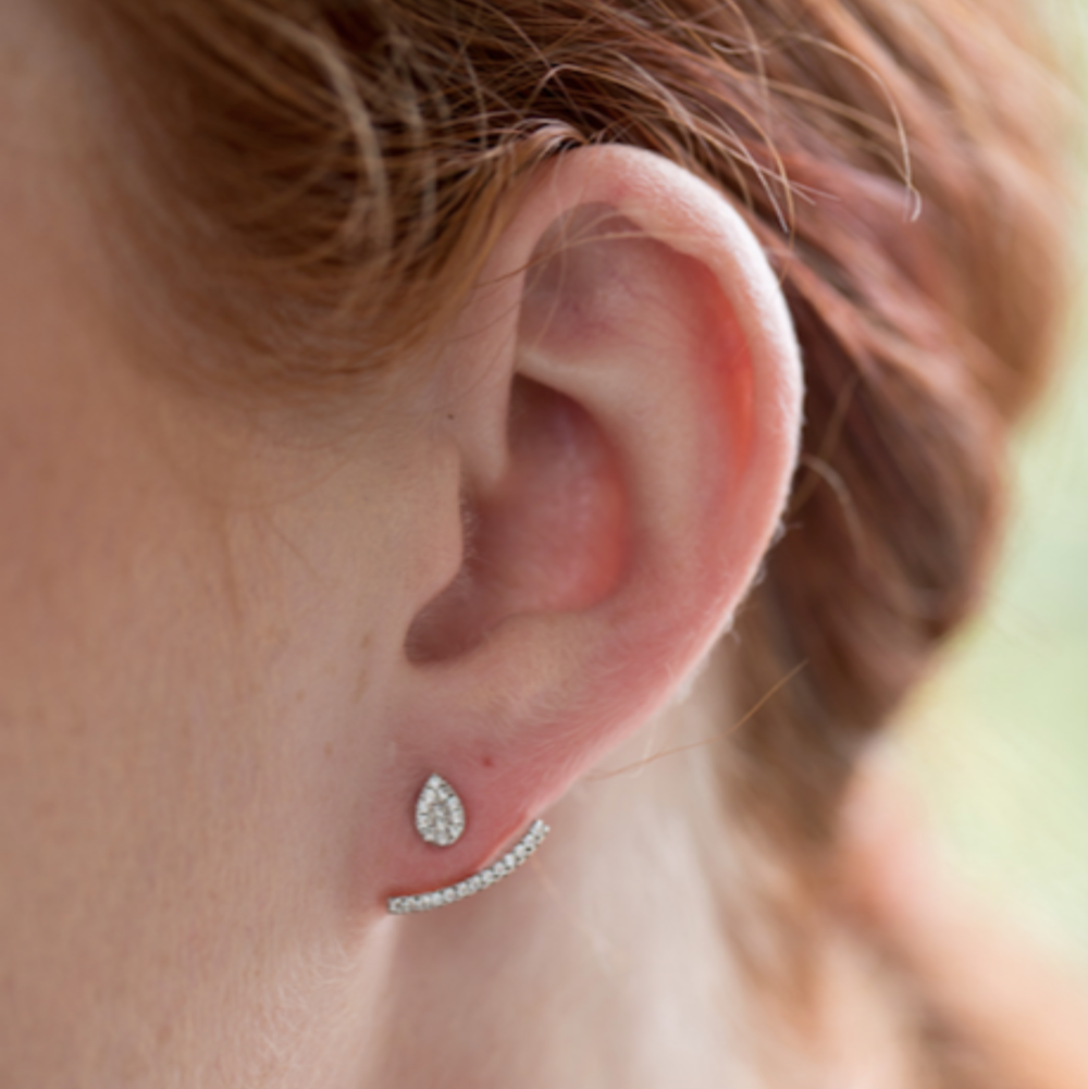 close up of model wearing tear dropped shaped earring, with cubic zirconia cuff that sits below the ear lobe