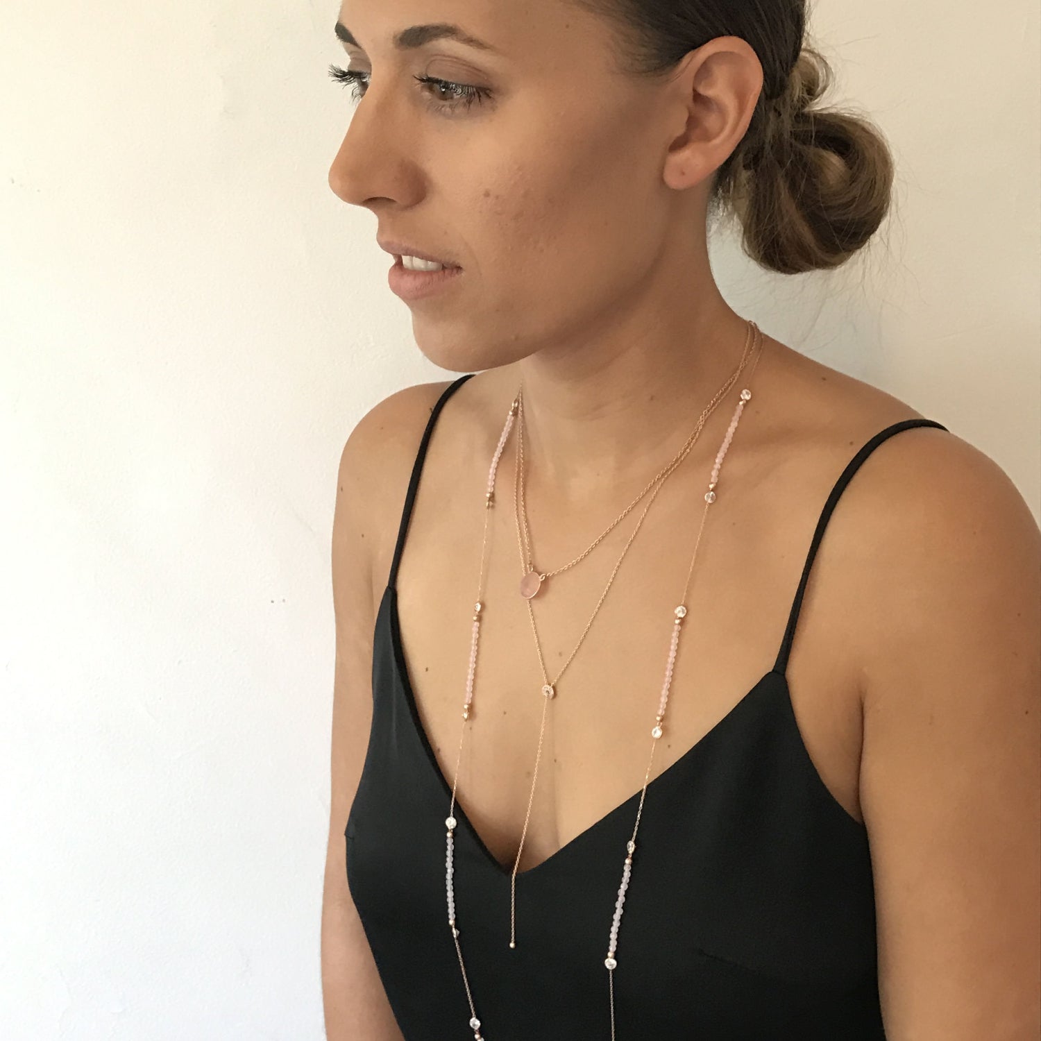 Model wearing gold plated Stunningly Simple Lariat Necklace, layered with other necklaces