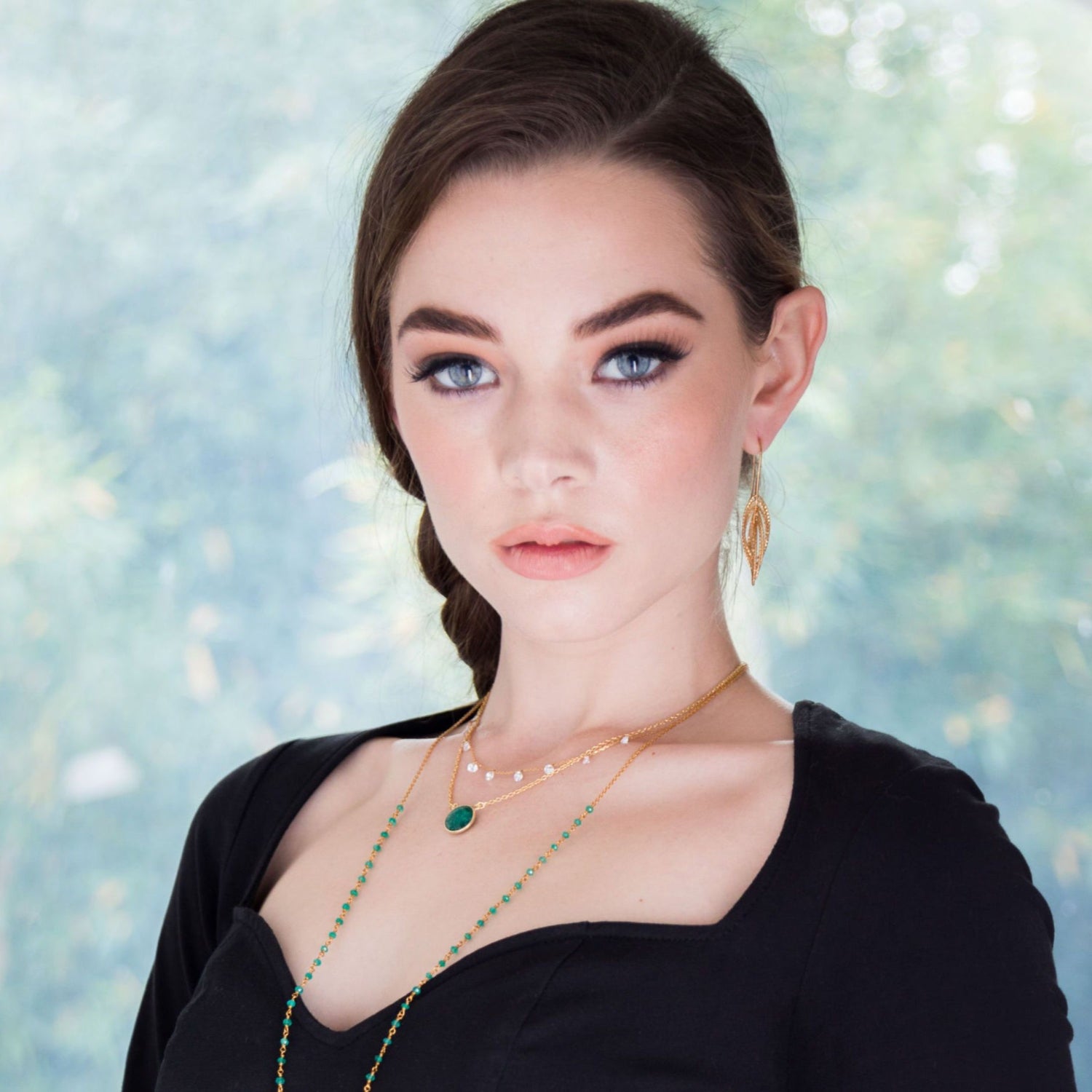 model wears Pretty Cubic Zirconia Drop Necklace in gold plated layered with other pieces