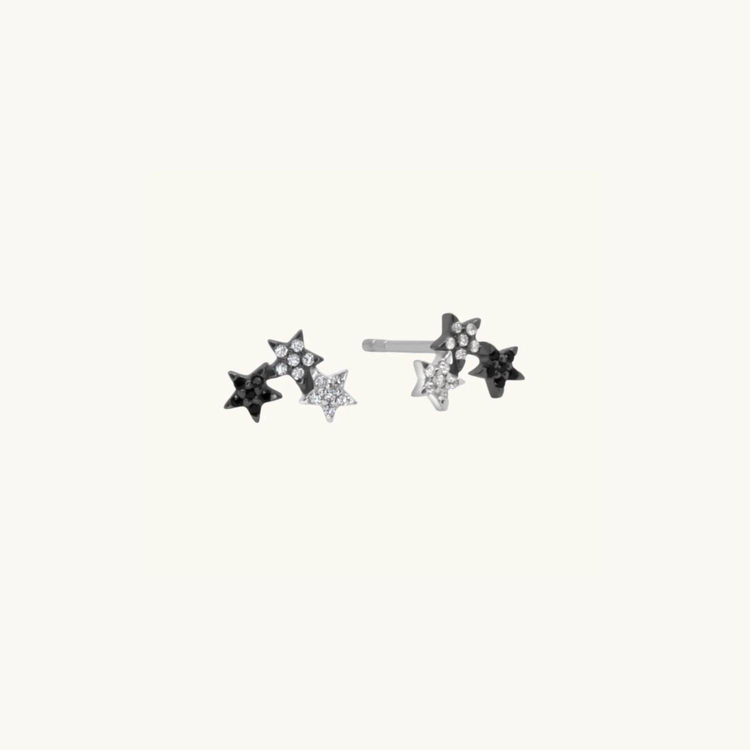 two colour star earrings in sterling silver and black displayed on warm cream background