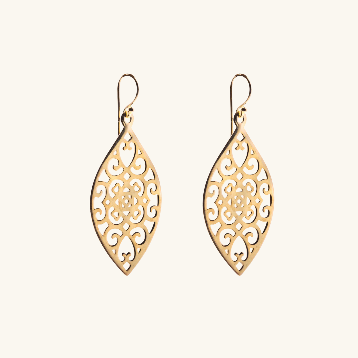 Gold earrings with intricate designs on a white background