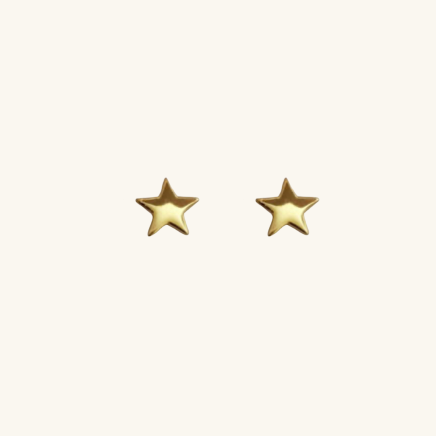 Gold star-shaped earrings on a white background