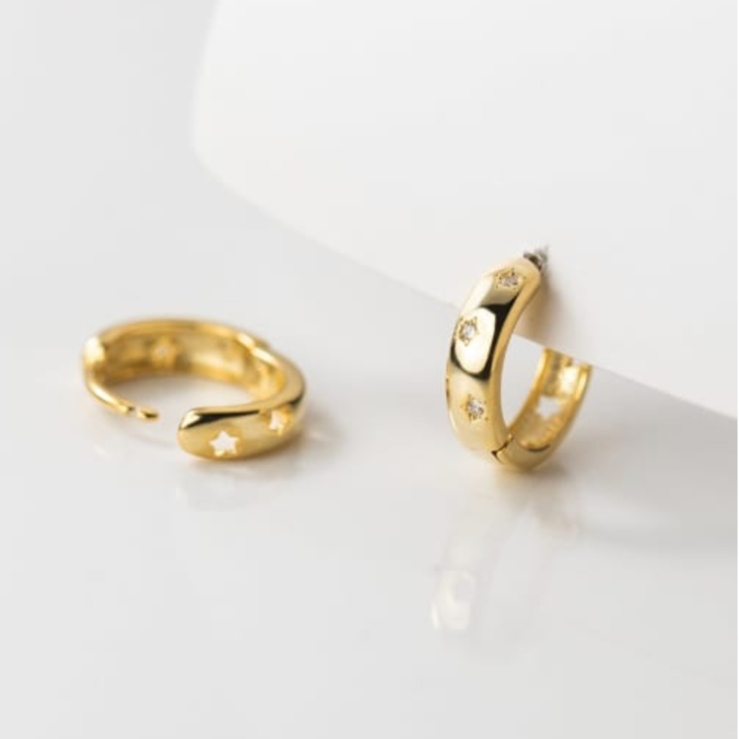 Gold hoop earrings on a light gray background