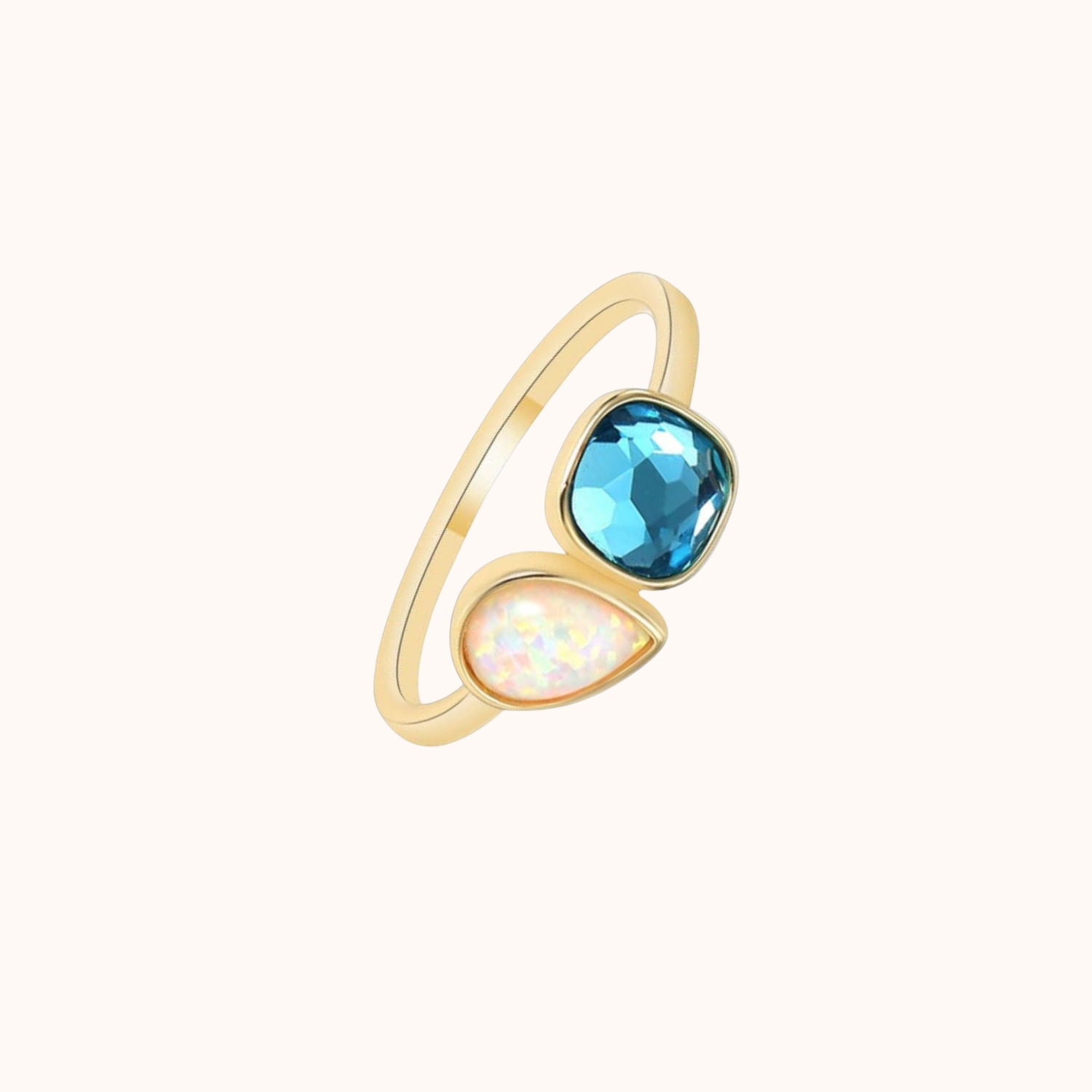 Gold ring with blue and clear gemstones on a white background