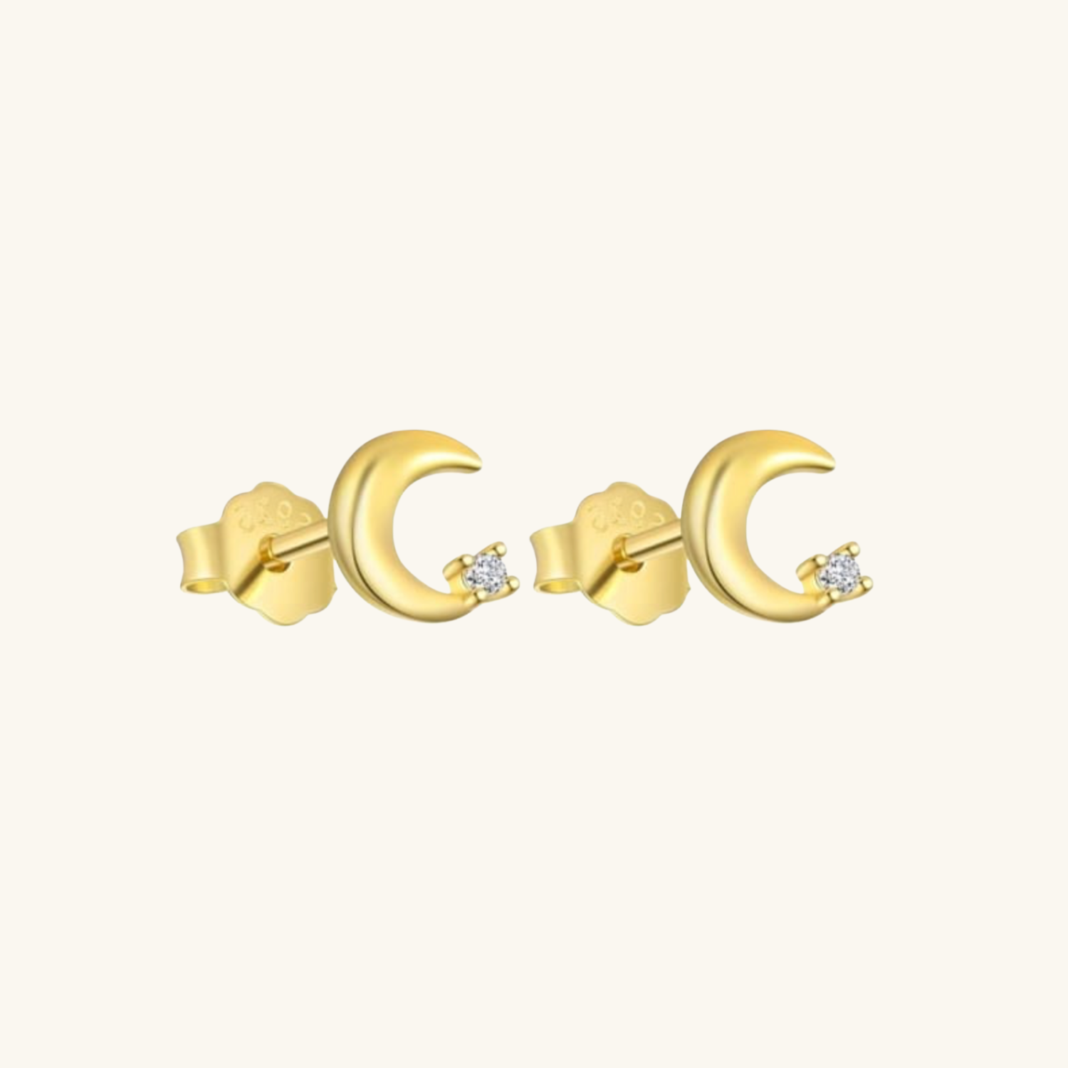 Gold moon-shaped earrings with small cubic zirconia on a white background