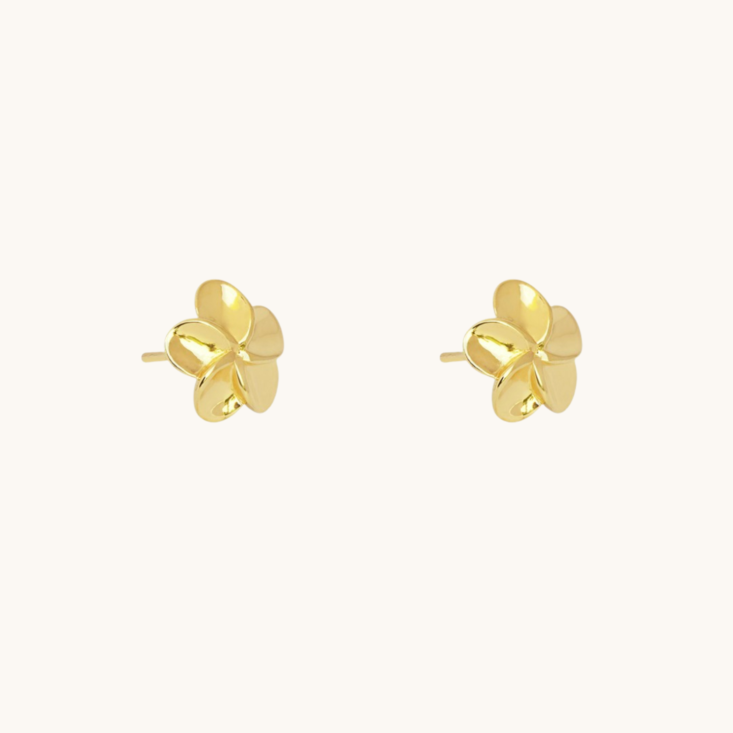 Gold floral earrings on a white background