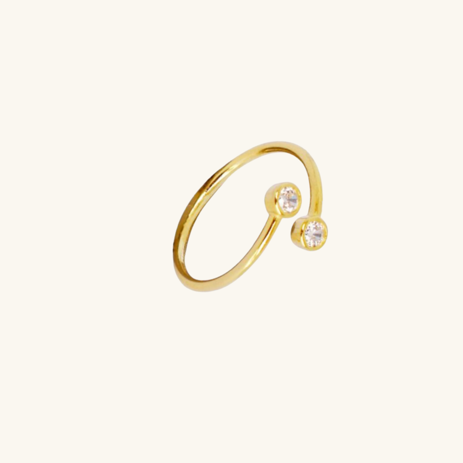Gold ring with two small cubic zirconia on a white background