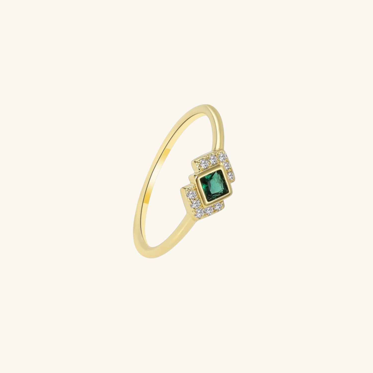 Gold ring with a green gemstone on a white background