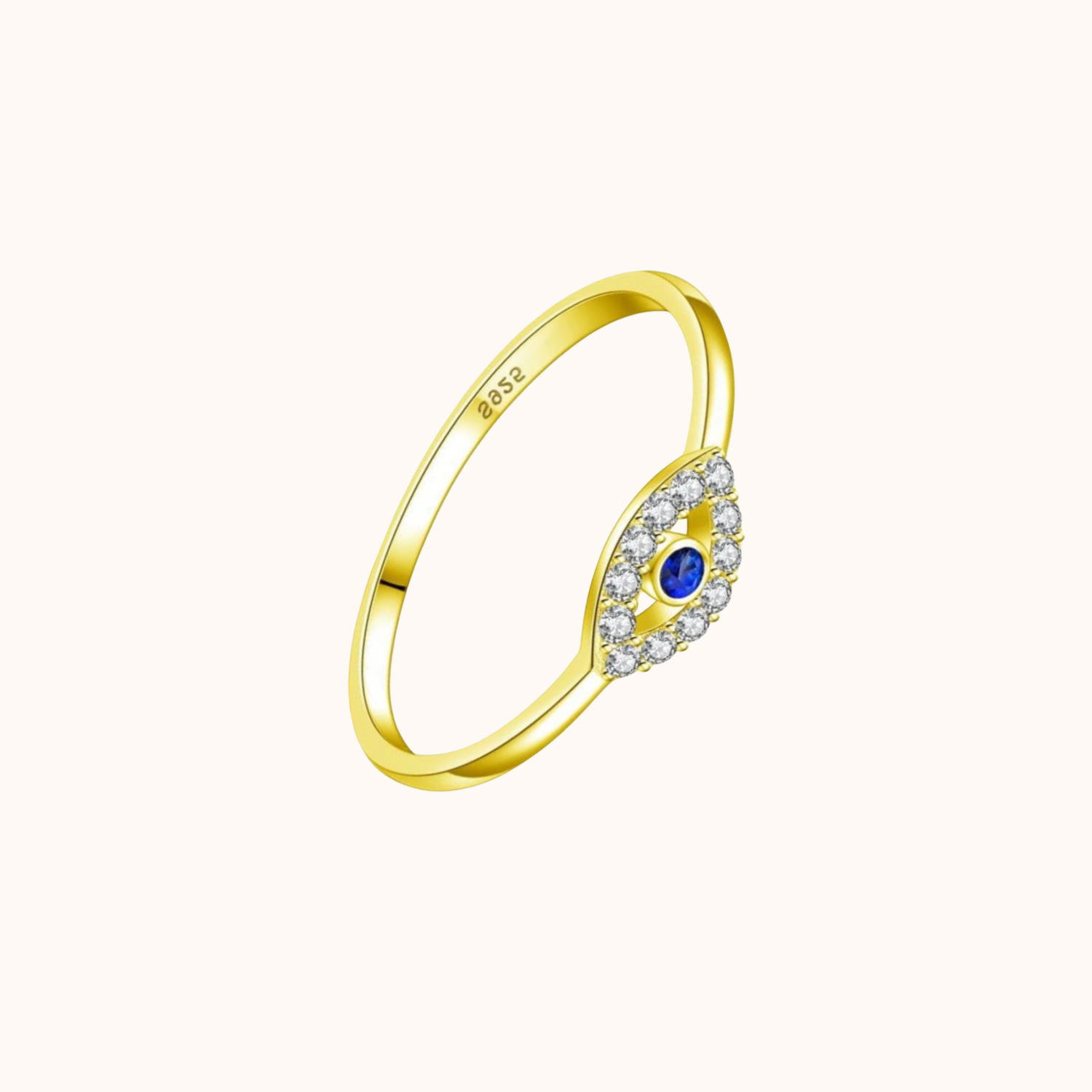 Gold ring with Evil eye design with a blue gemstone and clear stones on a white background