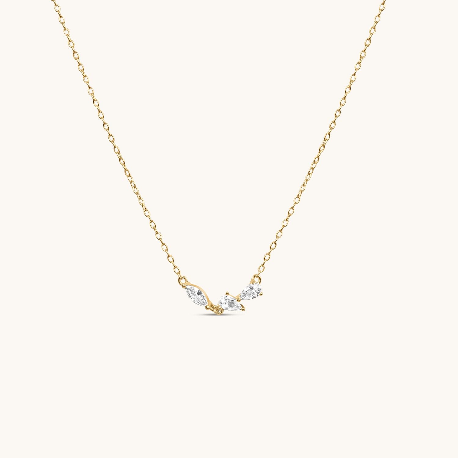 gold 3petals necklace hanging, with cream background