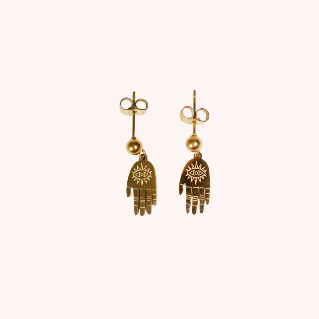 Gold hand-shaped earrings with eye design on a white background