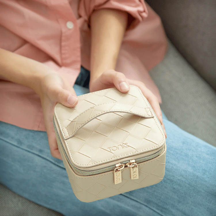 Model holding cream woven jewellery cube, demonstrating its size and portability