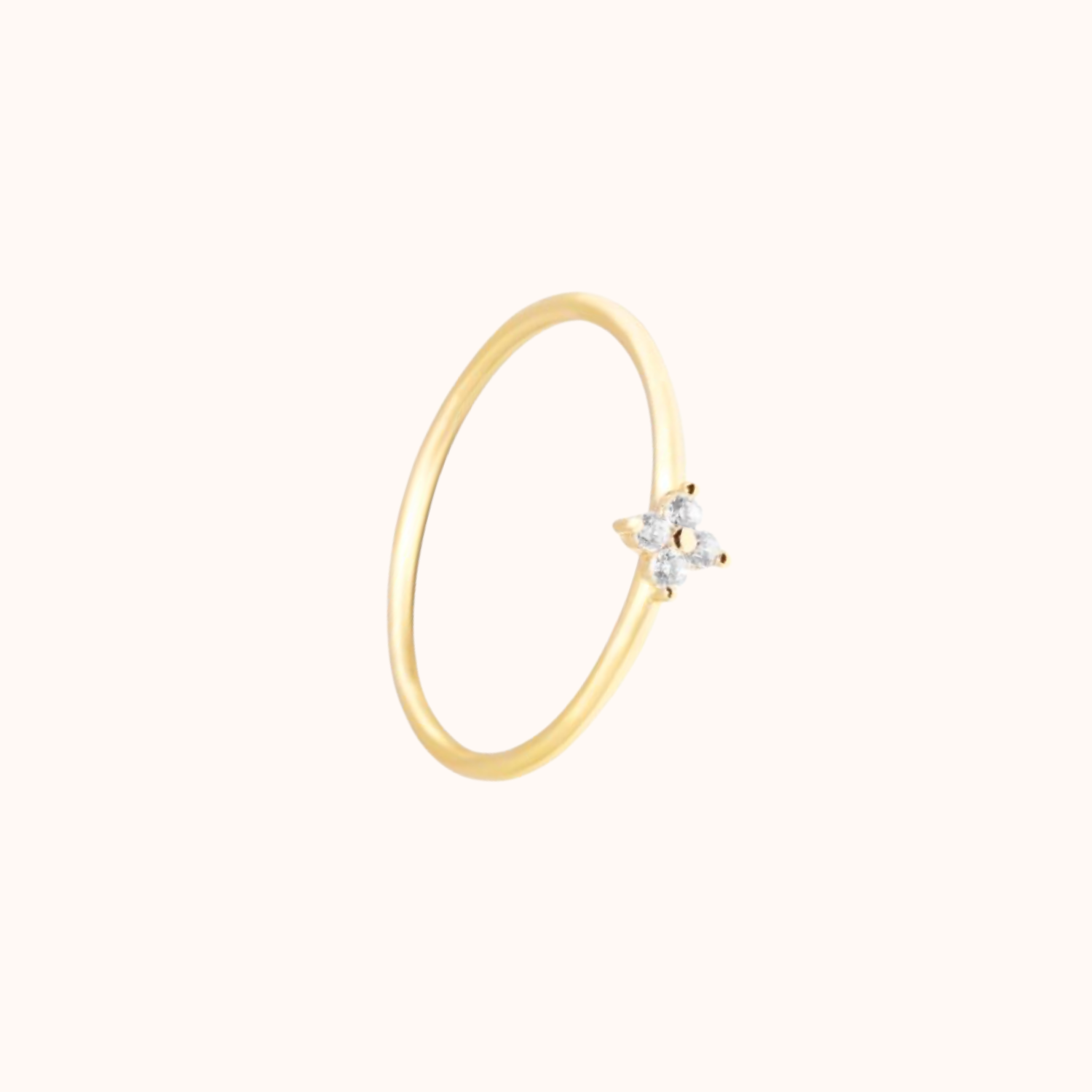 Small CZ on gold band, on cream background