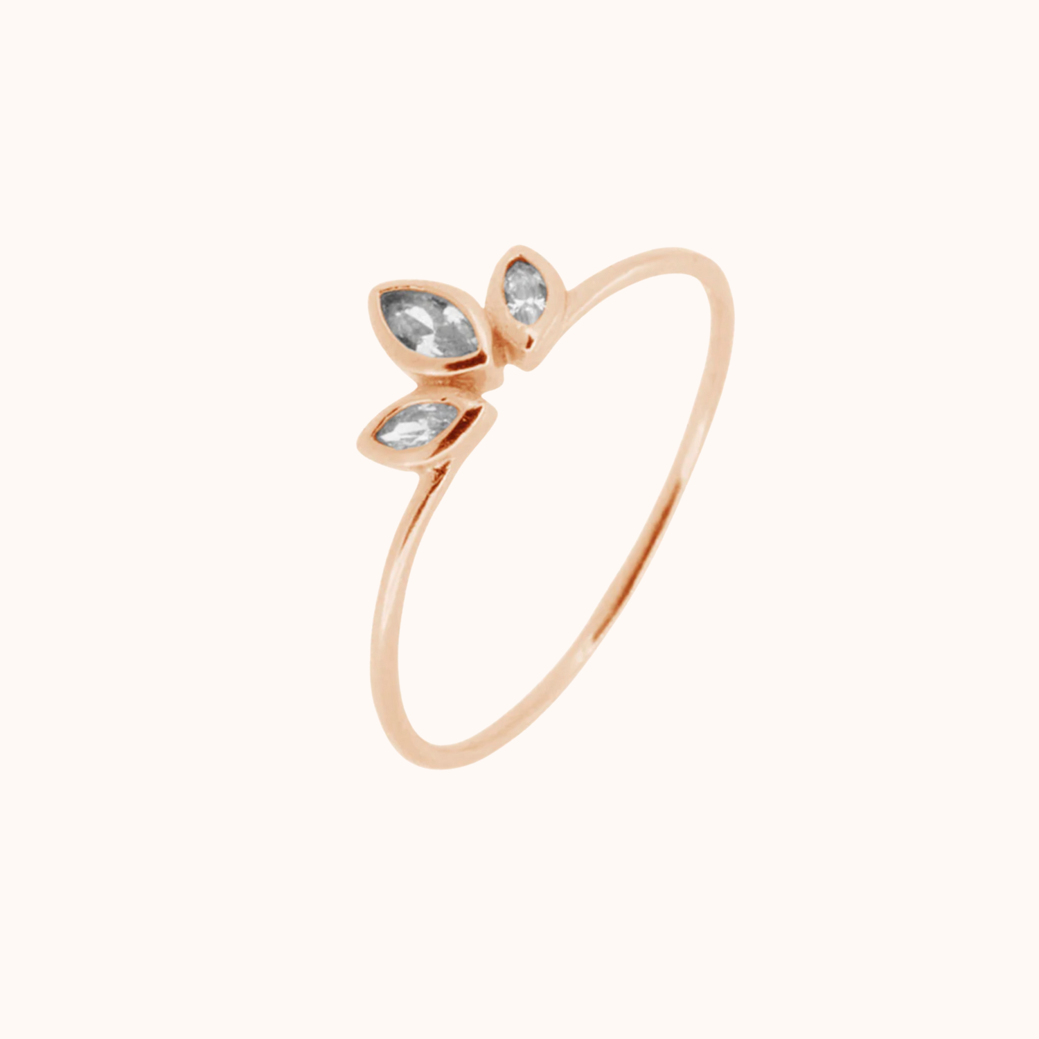 Rose gold ring with three clear gemstones on a white background