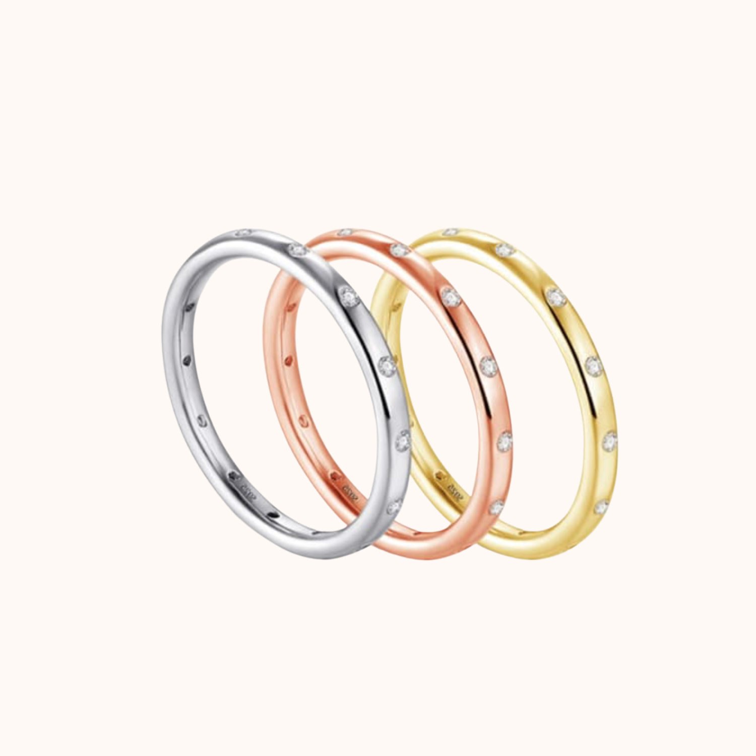 Three rings in silver, rose gold, and yellow gold on a white background