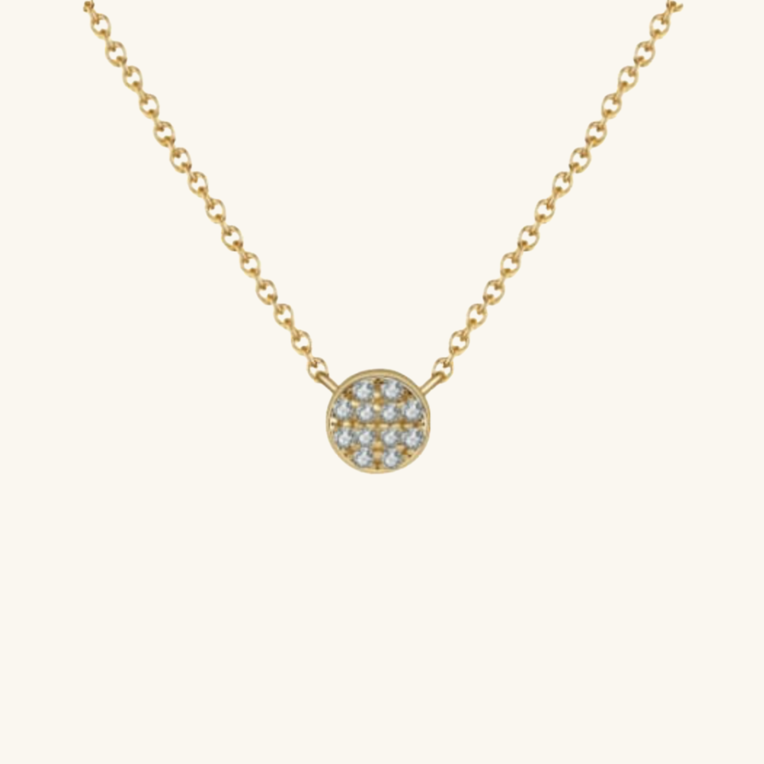 Gold necklace with a round pendant on a white background