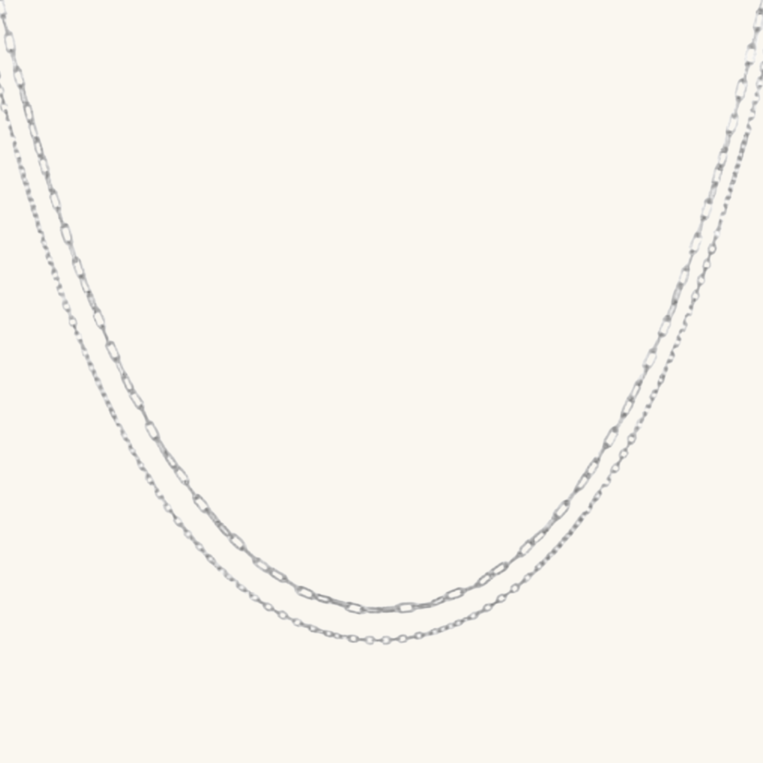 Silver chain necklace on a light gray background