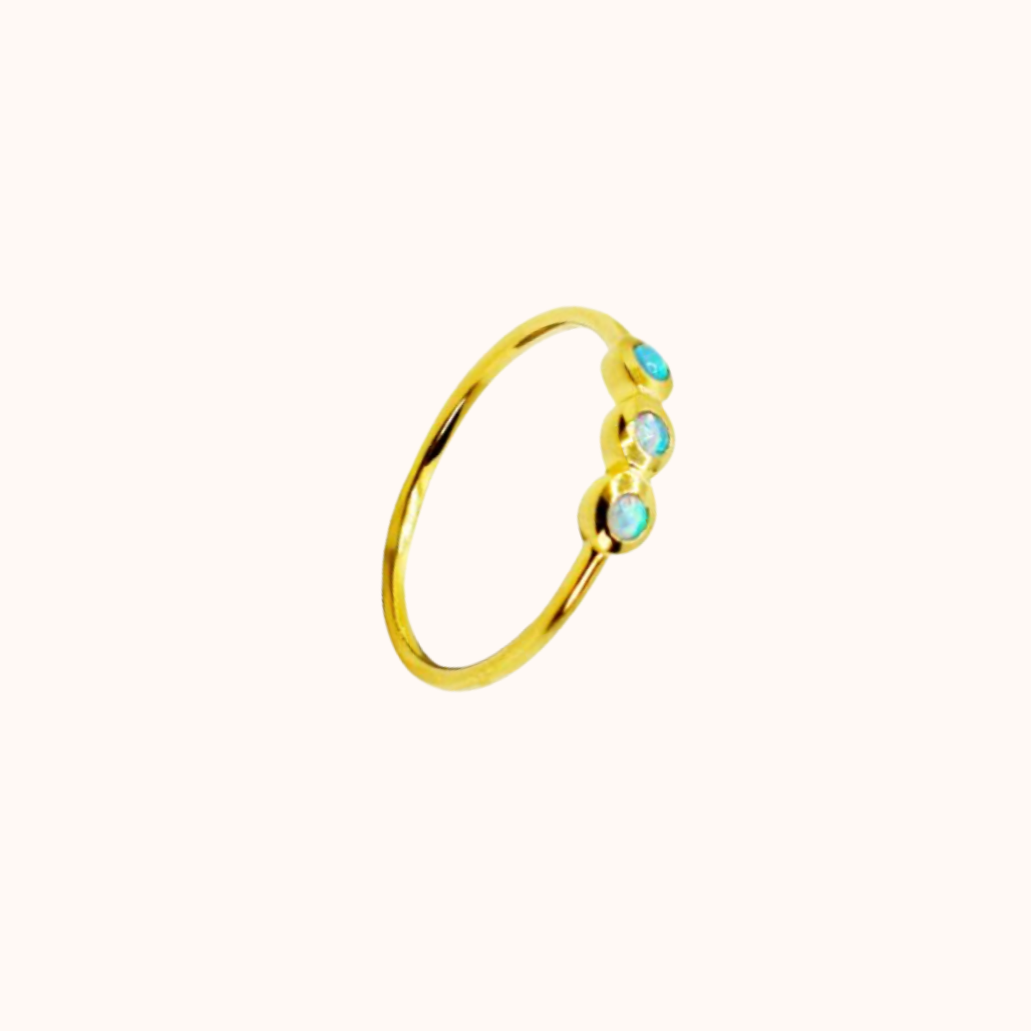 Gold ring with turquoise opalite stones on a white background