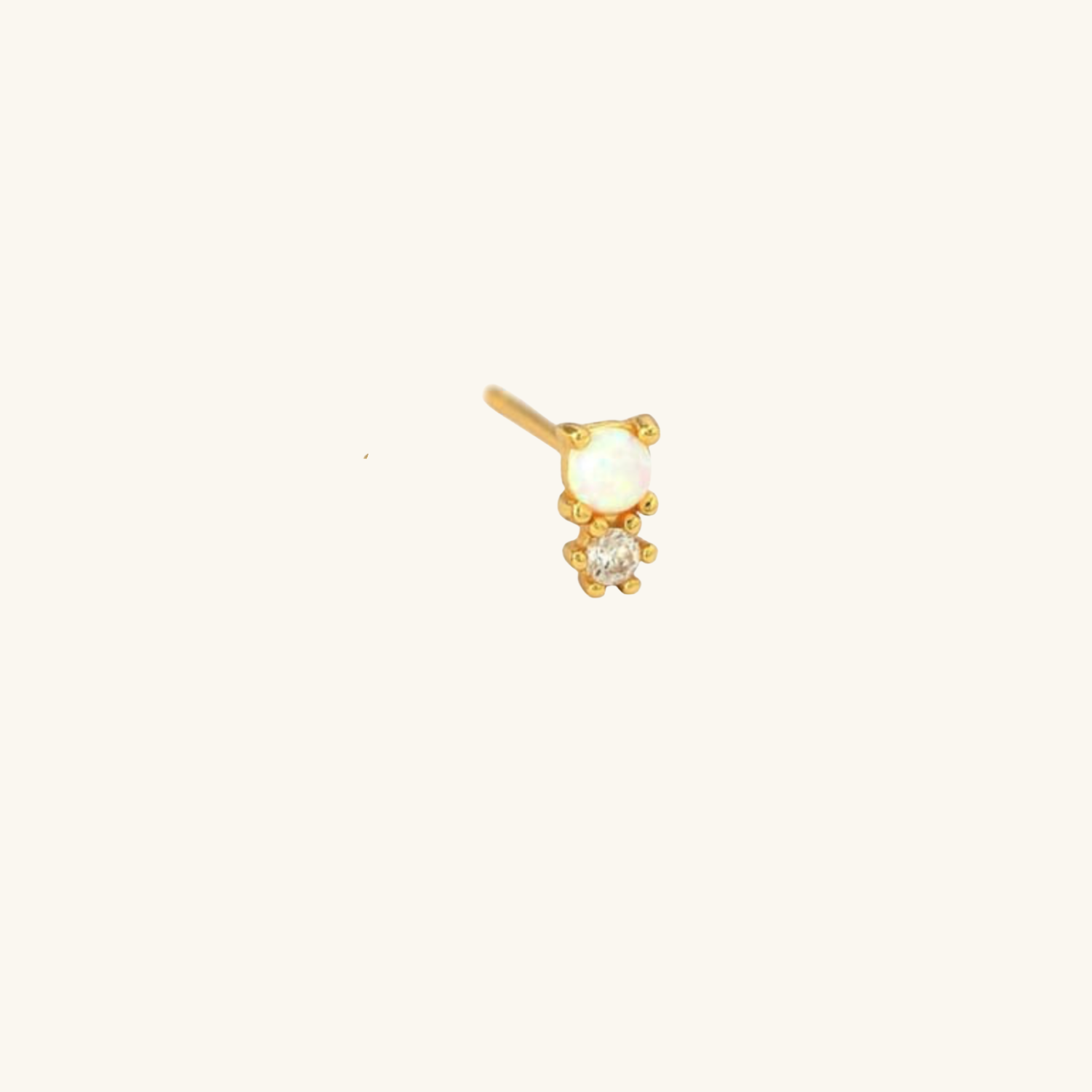 Gold earring with moonstone and cubic zirconia on a white background