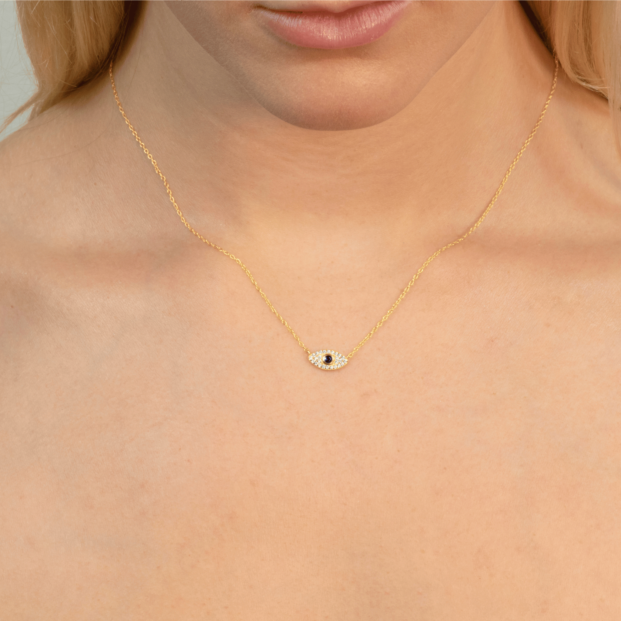 Model wears gold evil eye necklace