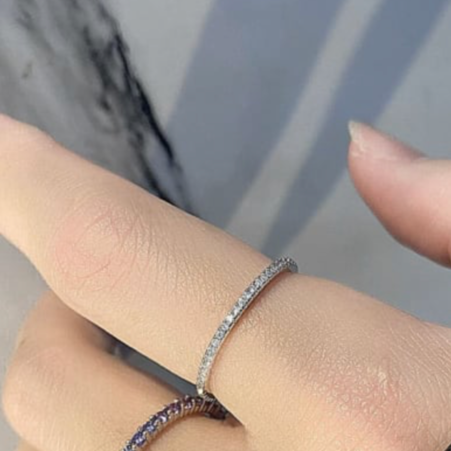 Close-up of a hand wearing a silver ring with a blurred background