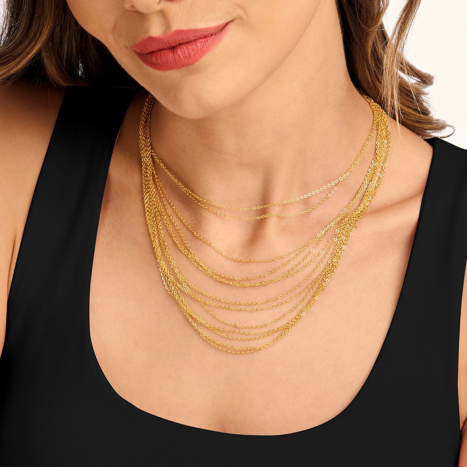 Model wearing a multi-layered necklace made of multiple gold chains that cascade down, creating a stunning, eye-catching layered look