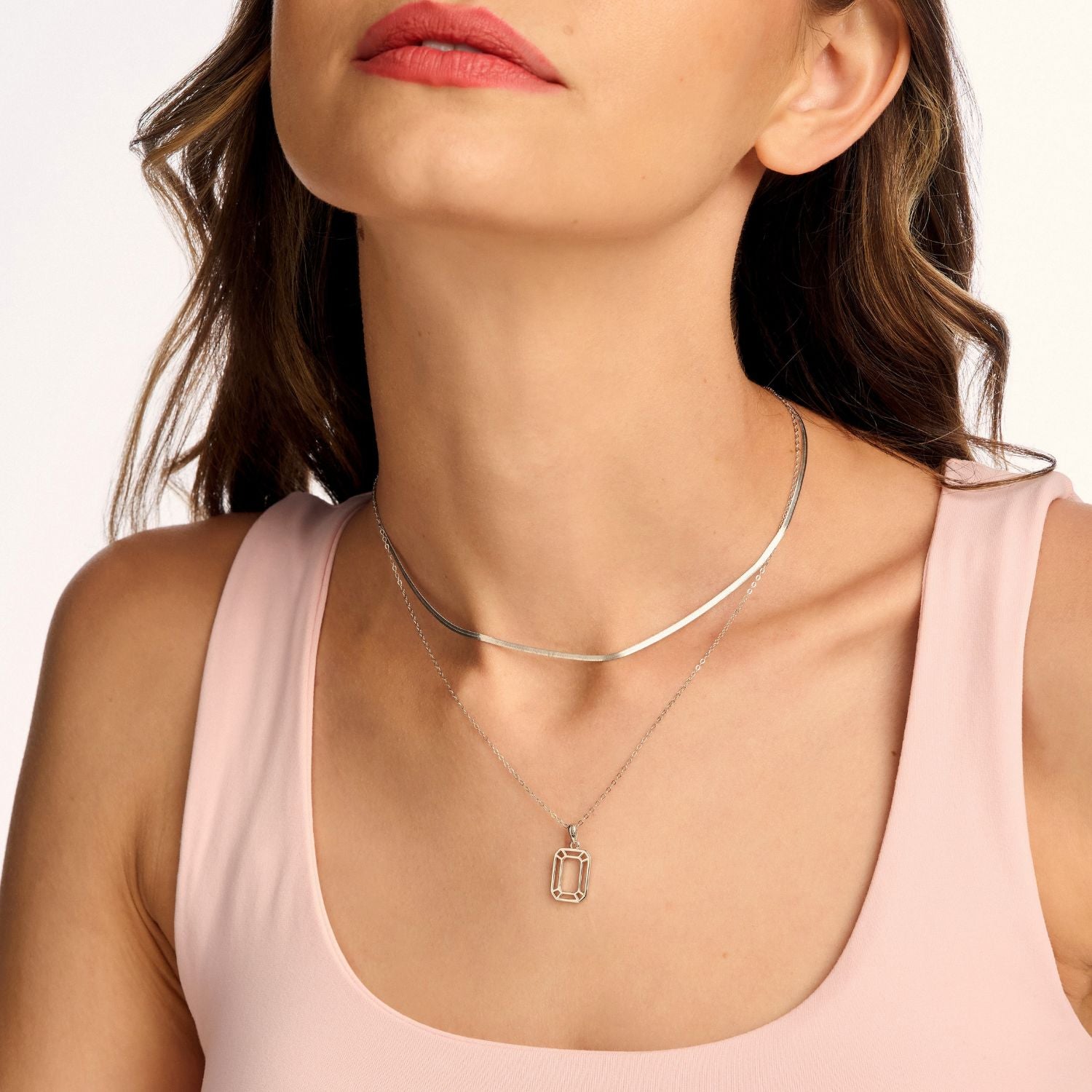 Model wearing a silver snake necklace, featuring a sleek, serpentine designed chain. A bold and elegant statement piece for any occasion.