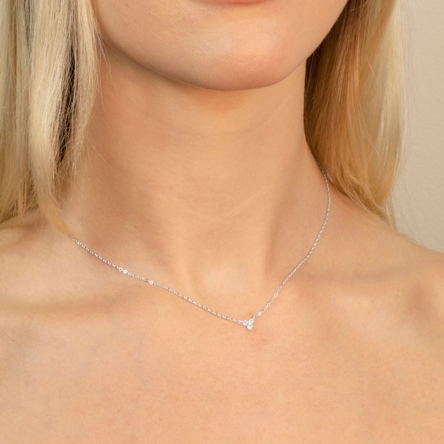 Model wearing a silver lotus flower necklace with shimmering cubic zirconia, highlighting its delicate design and timeless elegance