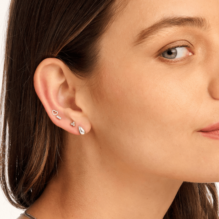 Model wearing small silver dome stud earrings, showcasing their sleek, minimalist design. A modern, on-trend accessory perfect for everyday wear