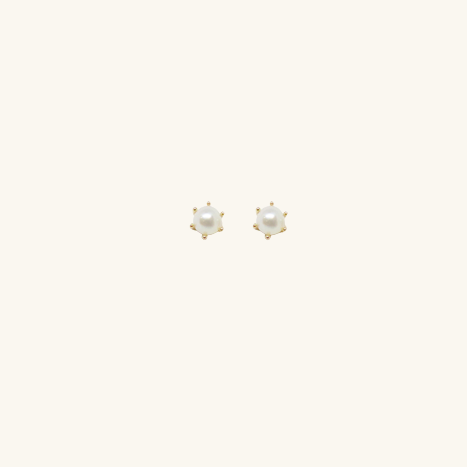 Freshwater pearl earrings with gold sitting, on cream background