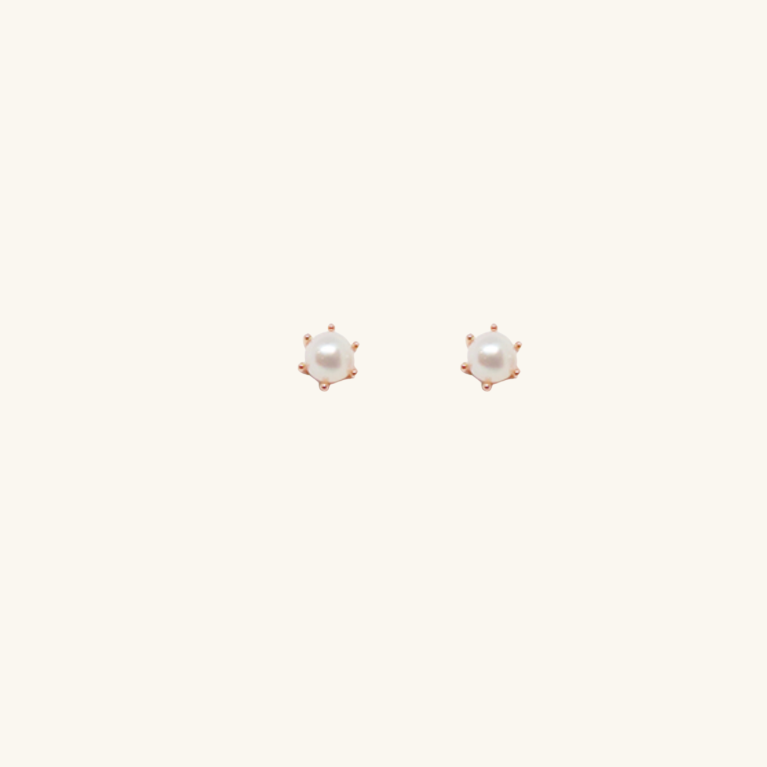 Pair of pearl stud earrings on a white background