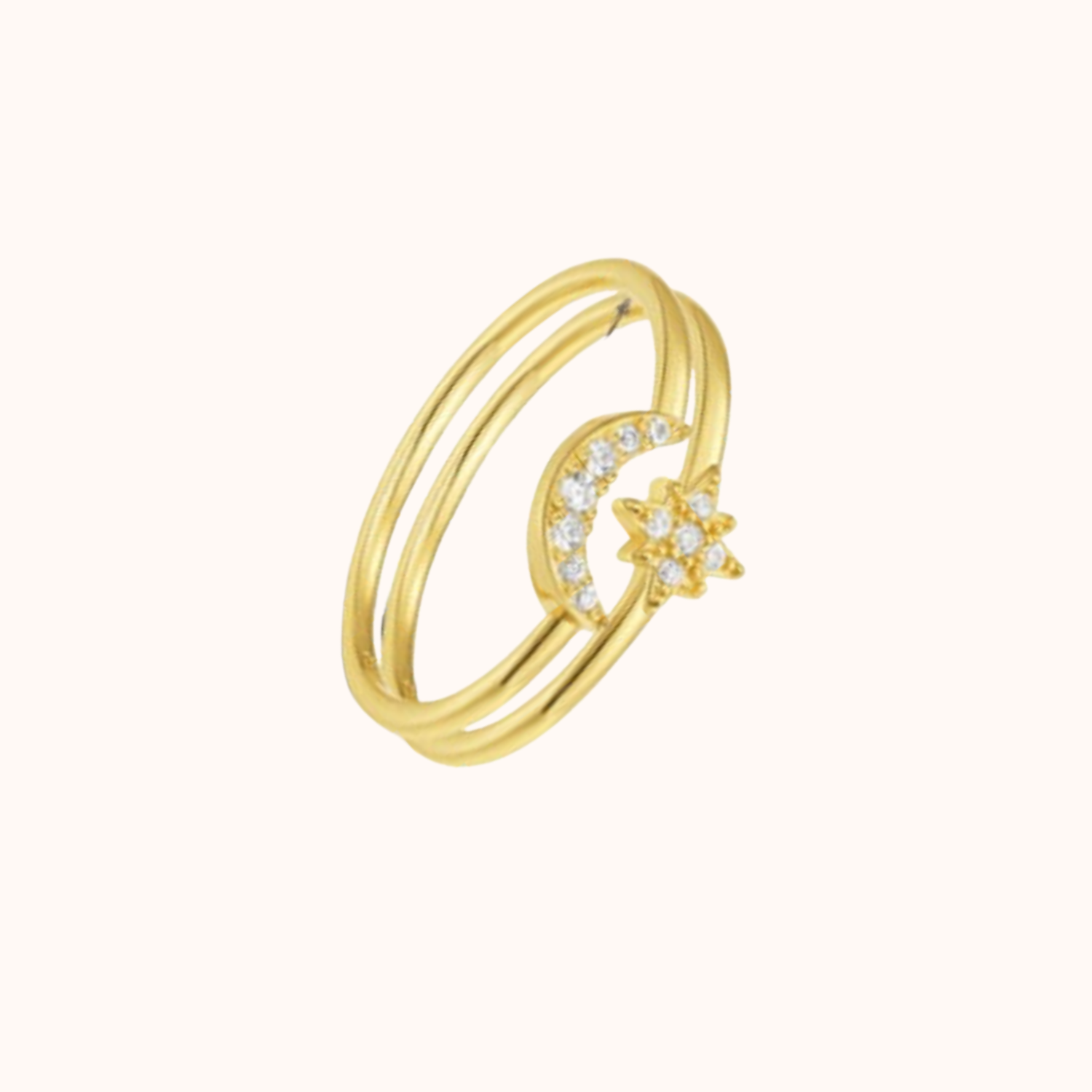 Gold ring with moon and star design on a white background