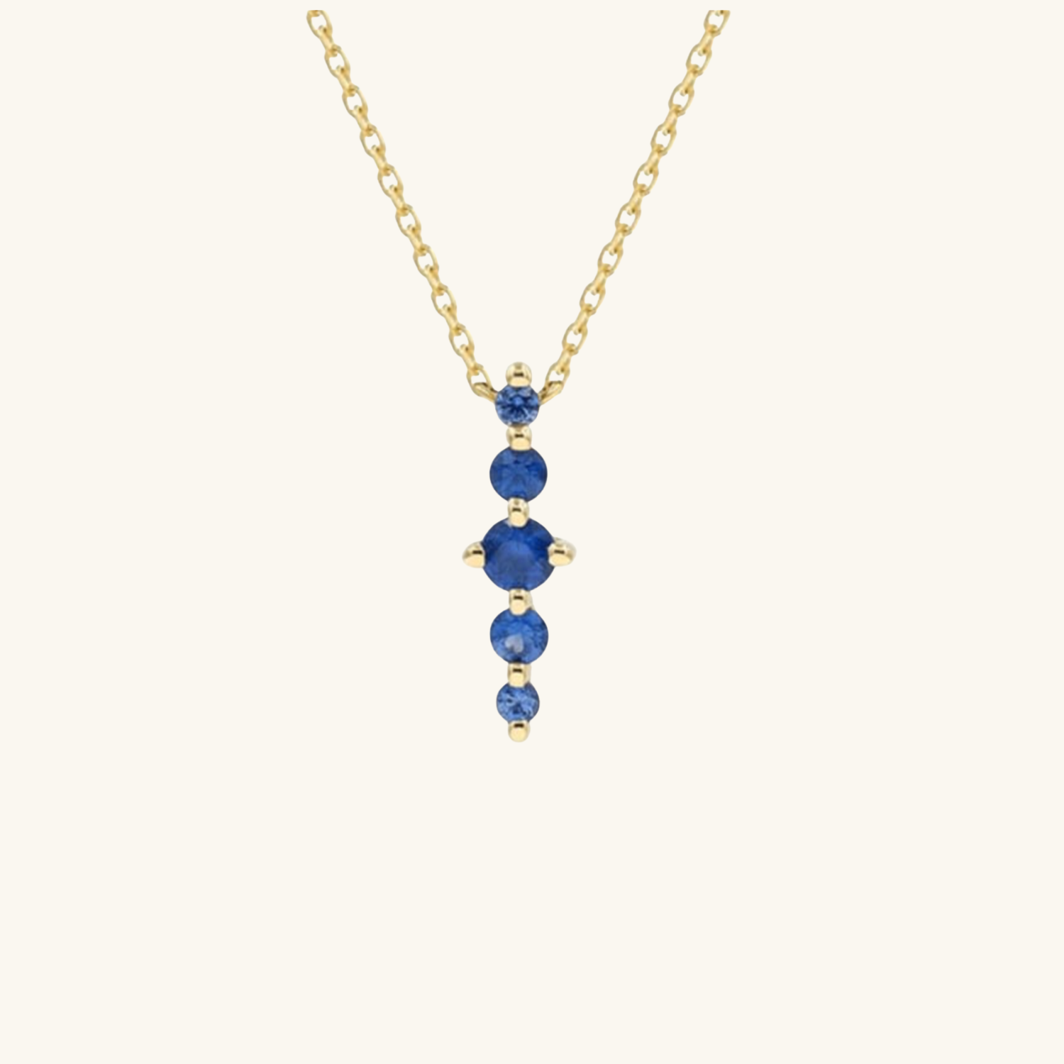 Gold necklace with blue gemstones on a white background