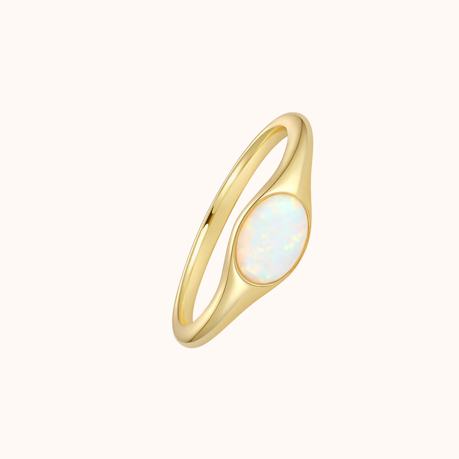 Gold ring with a white opal stone on a white background