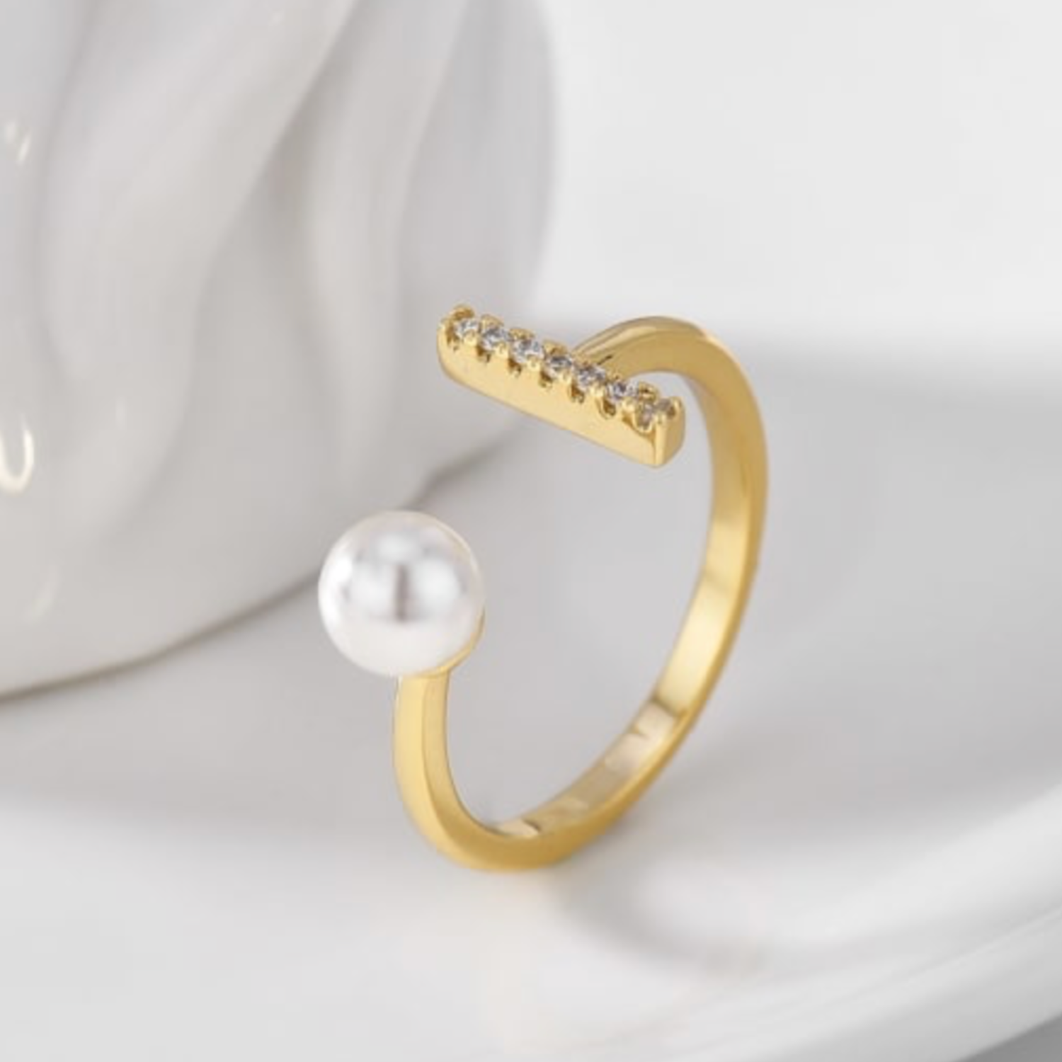 Gold ring with a pearl and CZ on a white background