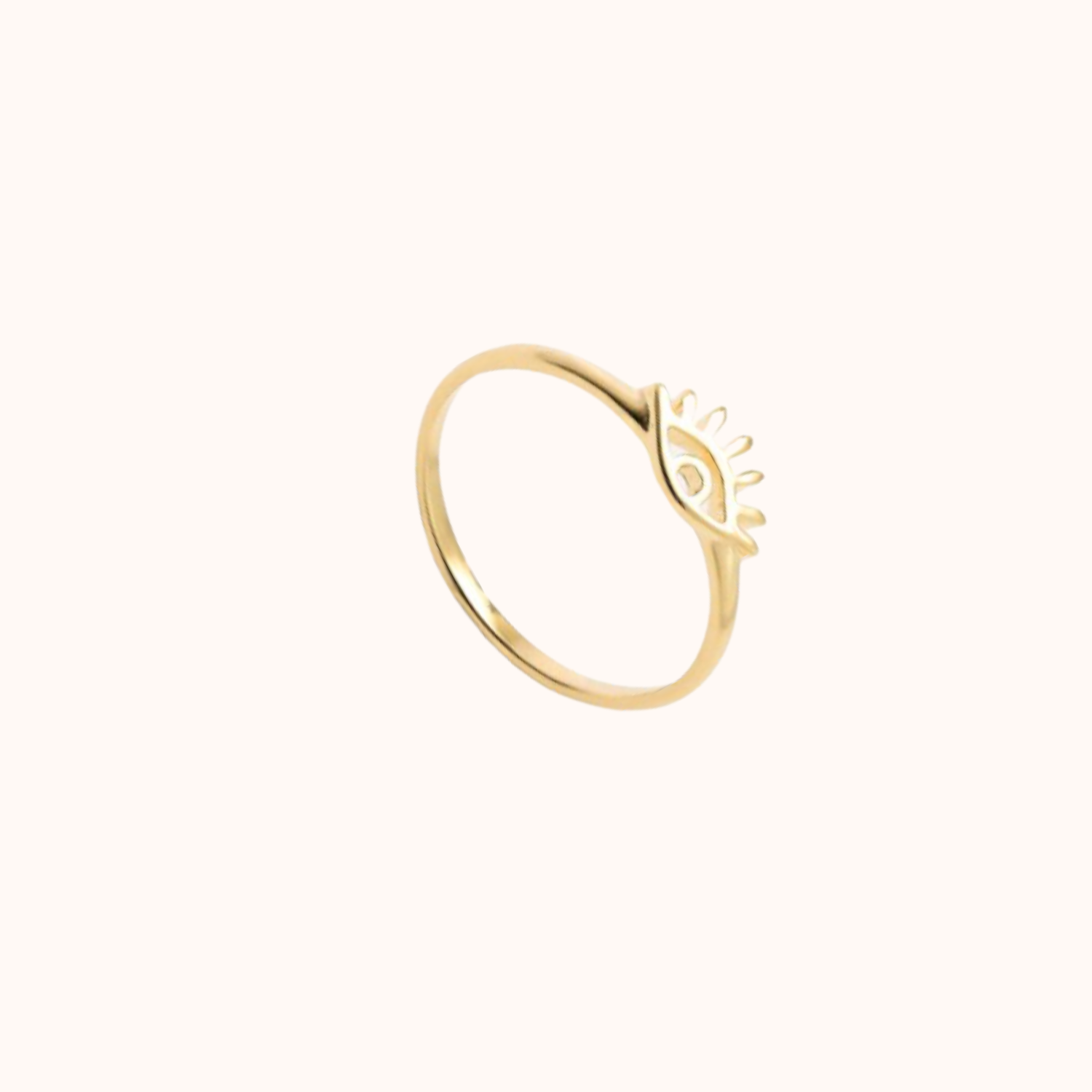 Evil eye gold ring on cream background