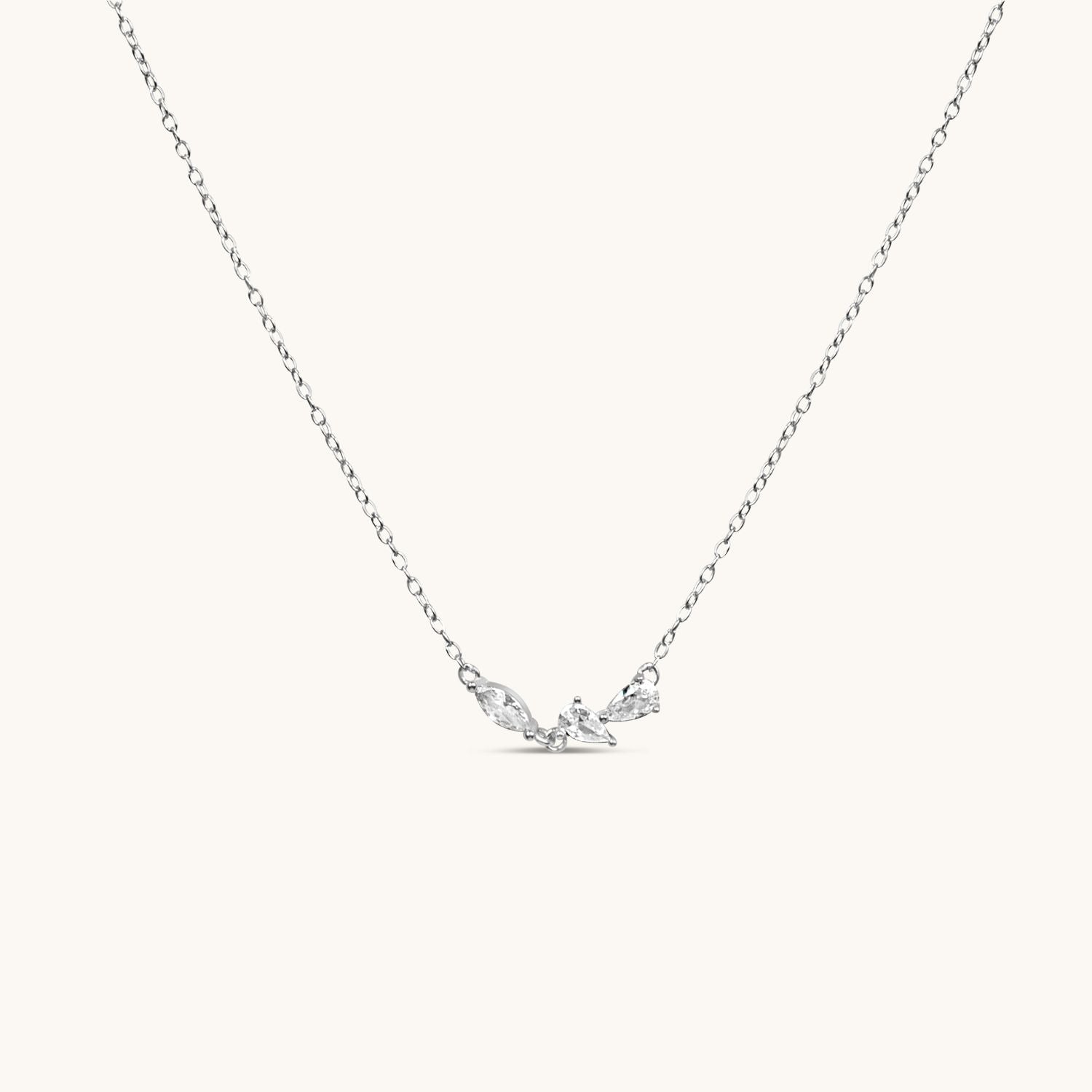 silver 3petals necklace hanging with cream background