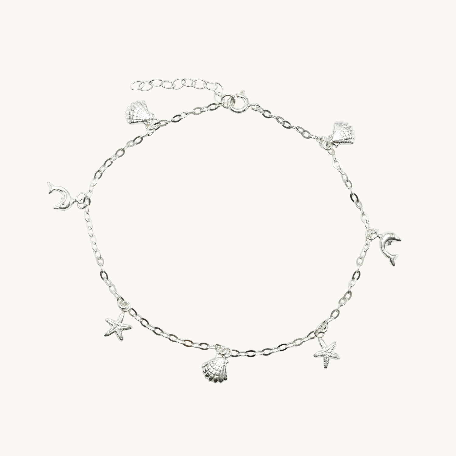 Silver anklet with star and shell charms on a white background