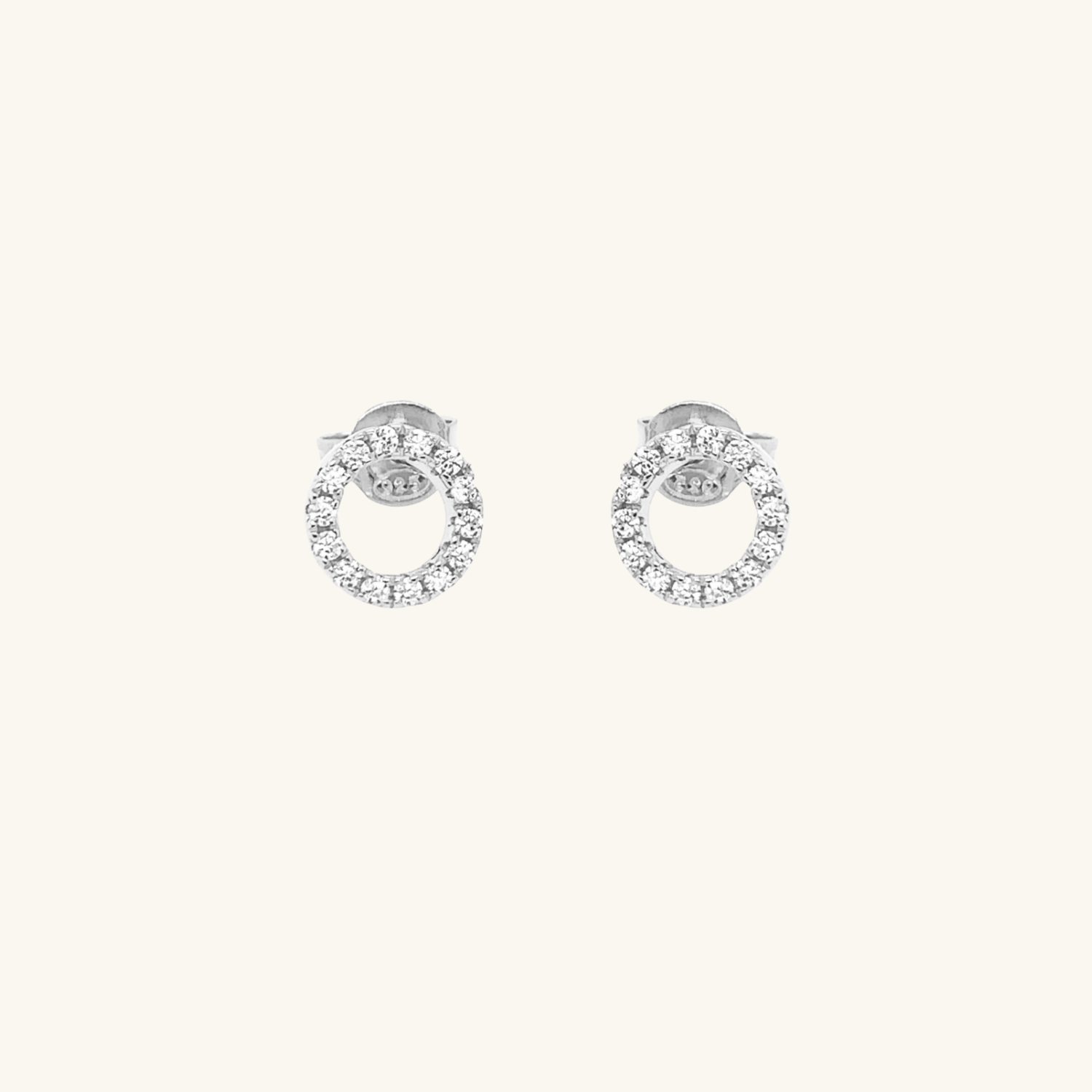 Pair of silver circle earrings with small cubic zirconia on a white background
