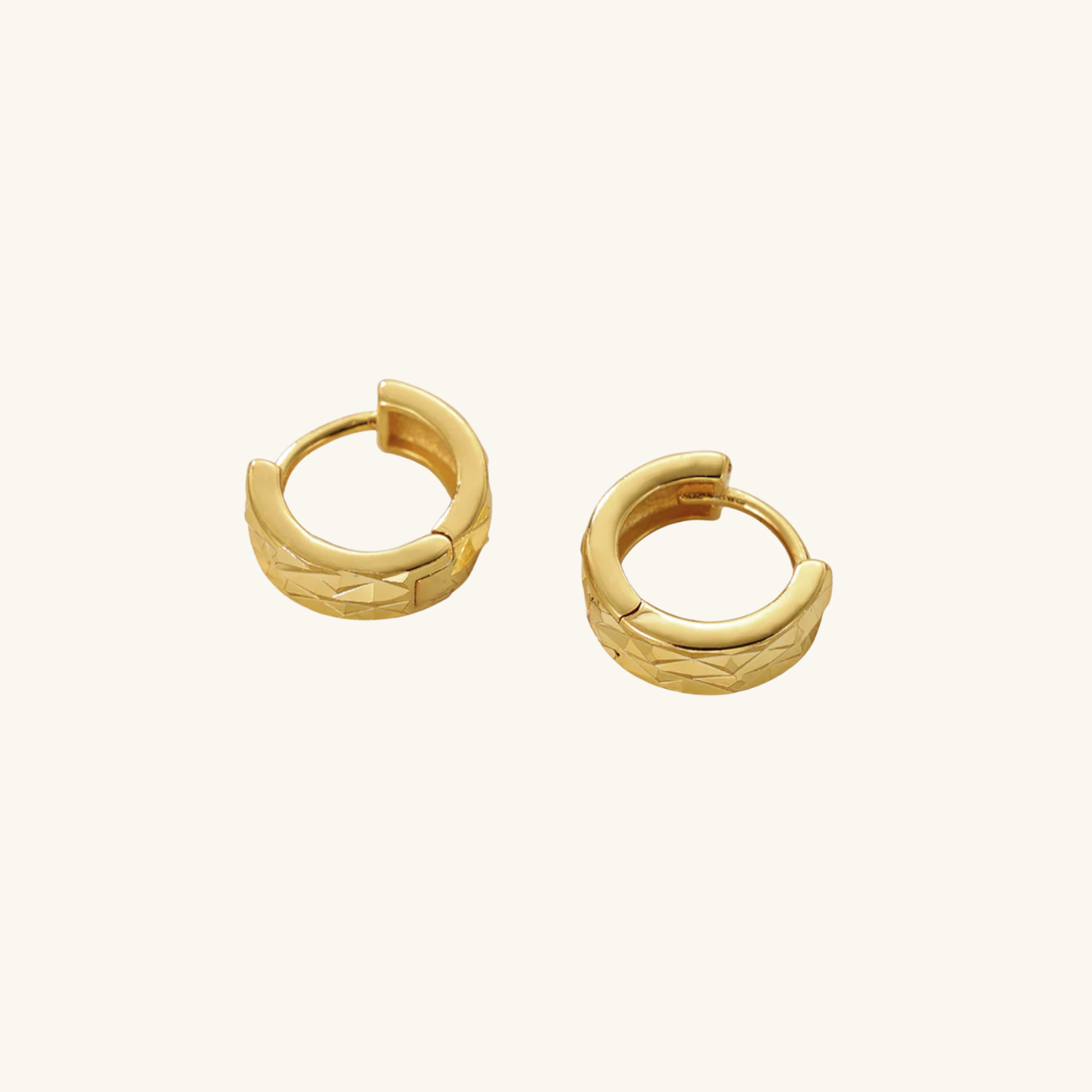 Textured huggie earrings on cream background