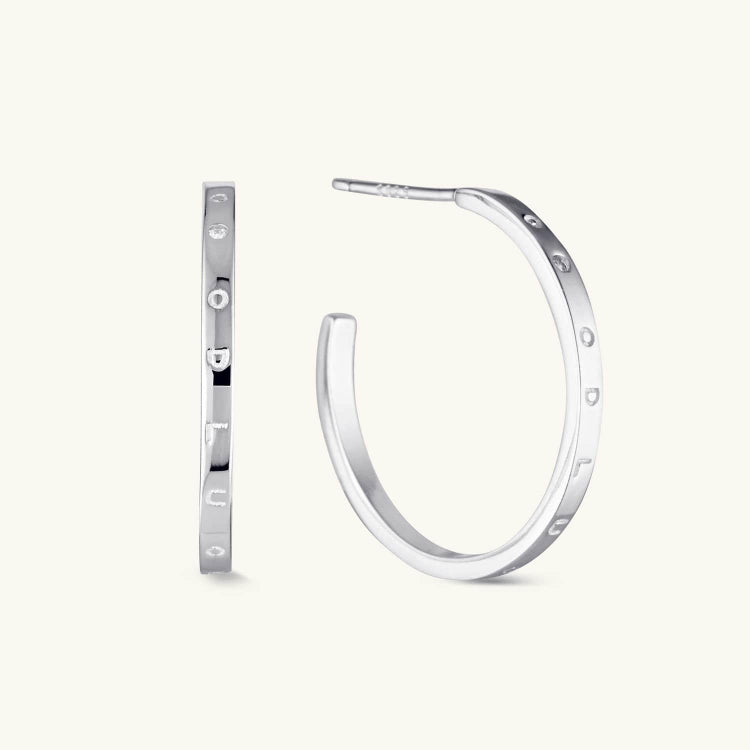 Silver decorative hoop earrings with intricate detailing and a timeless design. A stylish and versatile accessory for any occasion