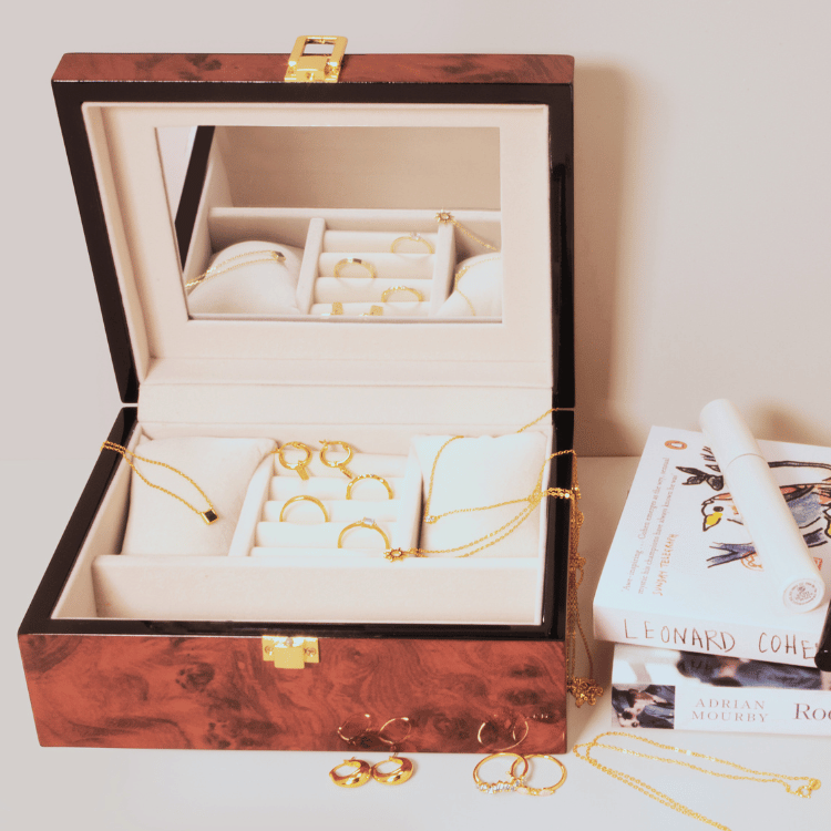 Wood finish jewellery box open with jewellery inside, highlighting soft lining, compartments, and an interior mirror