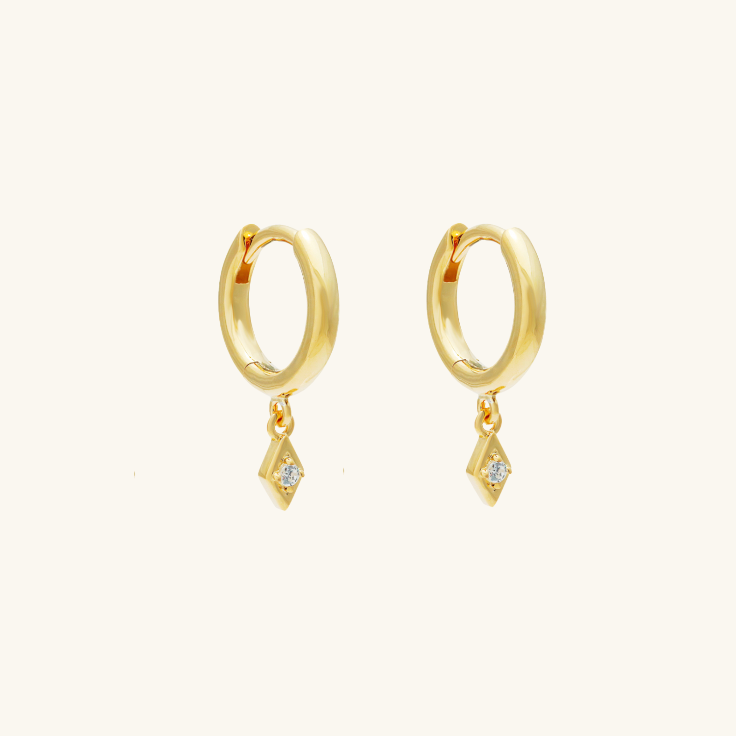 Gold hoop earrings with small diamond-like stones on a white background