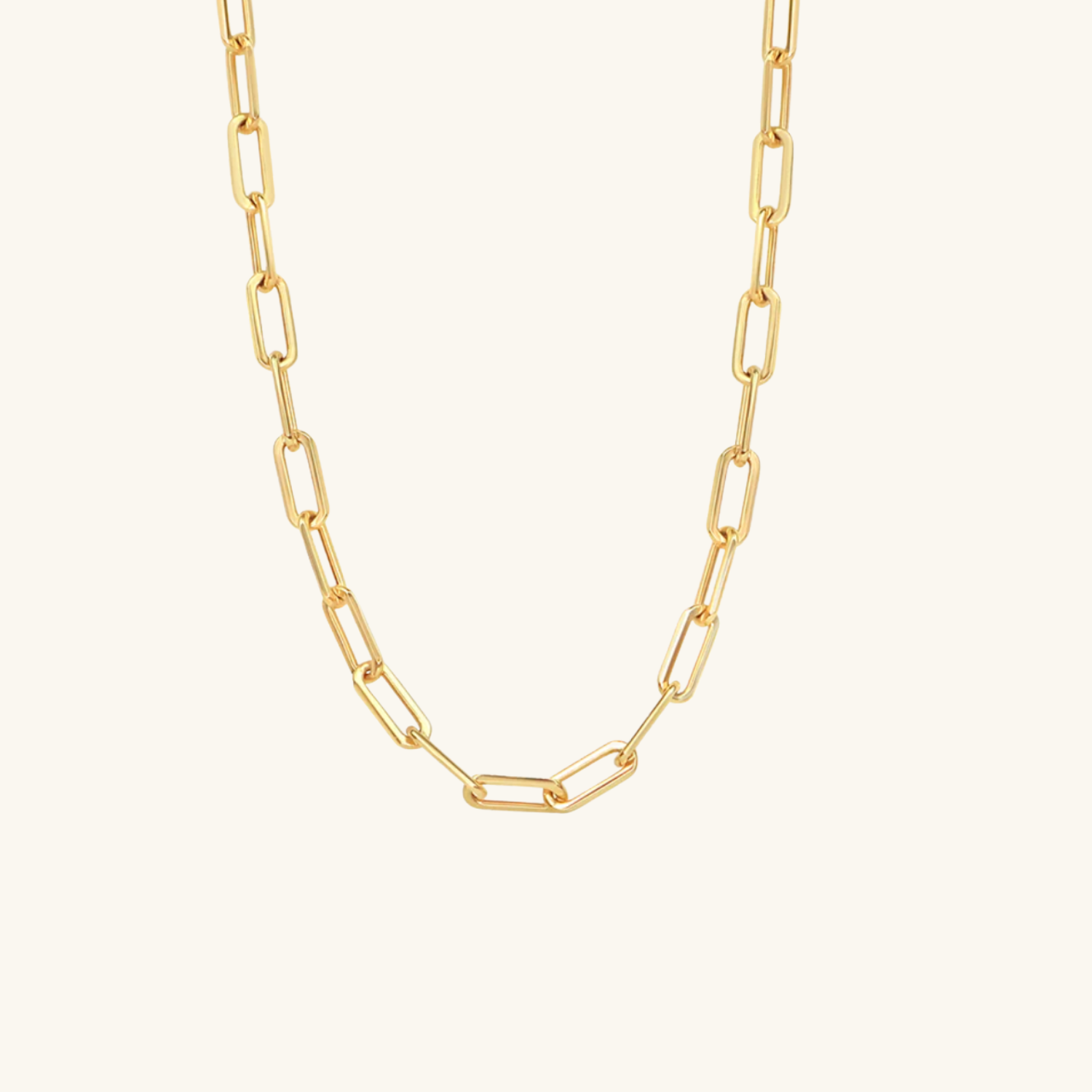 Gold chain necklace on a light beige background