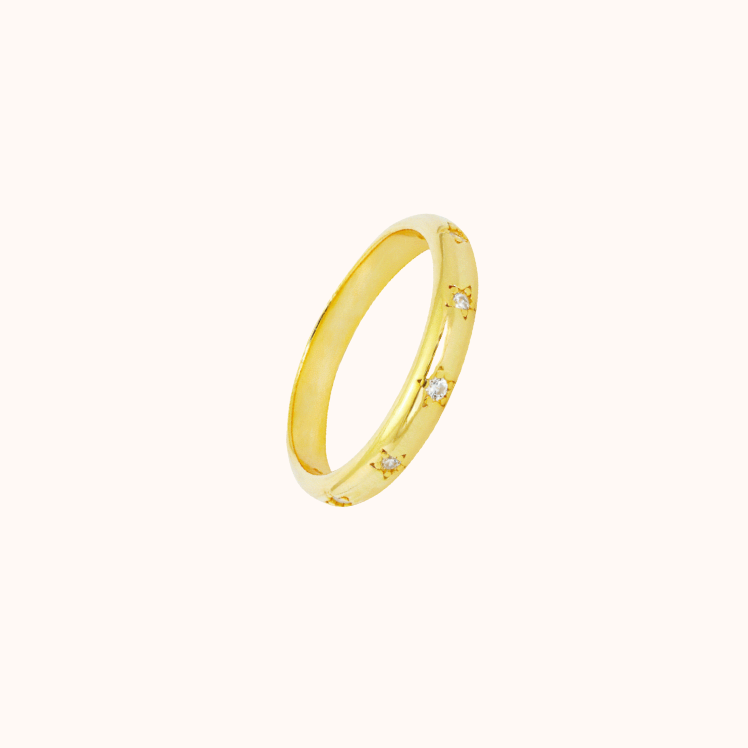 Gold starlight band ring on cream background