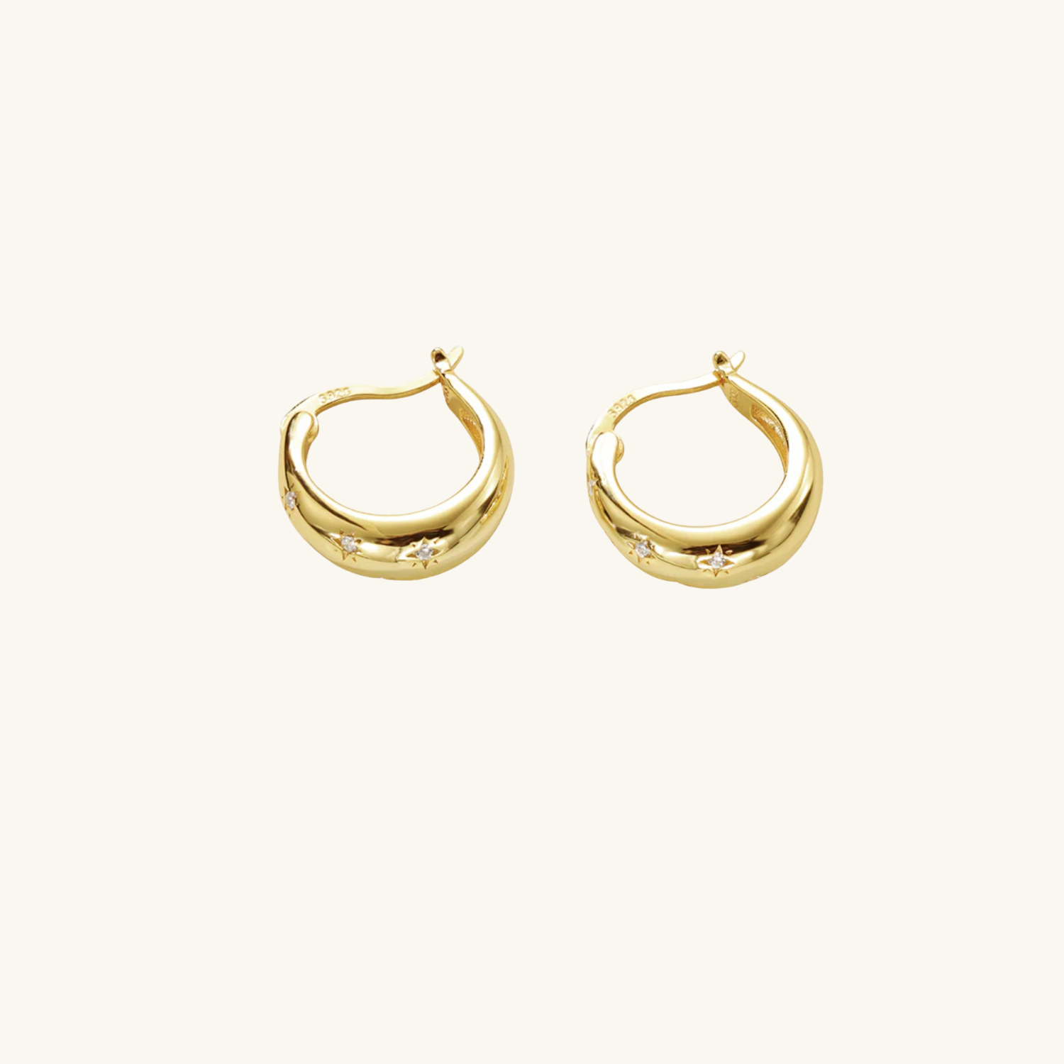 Gold hoop earrings flat lay image on a white background