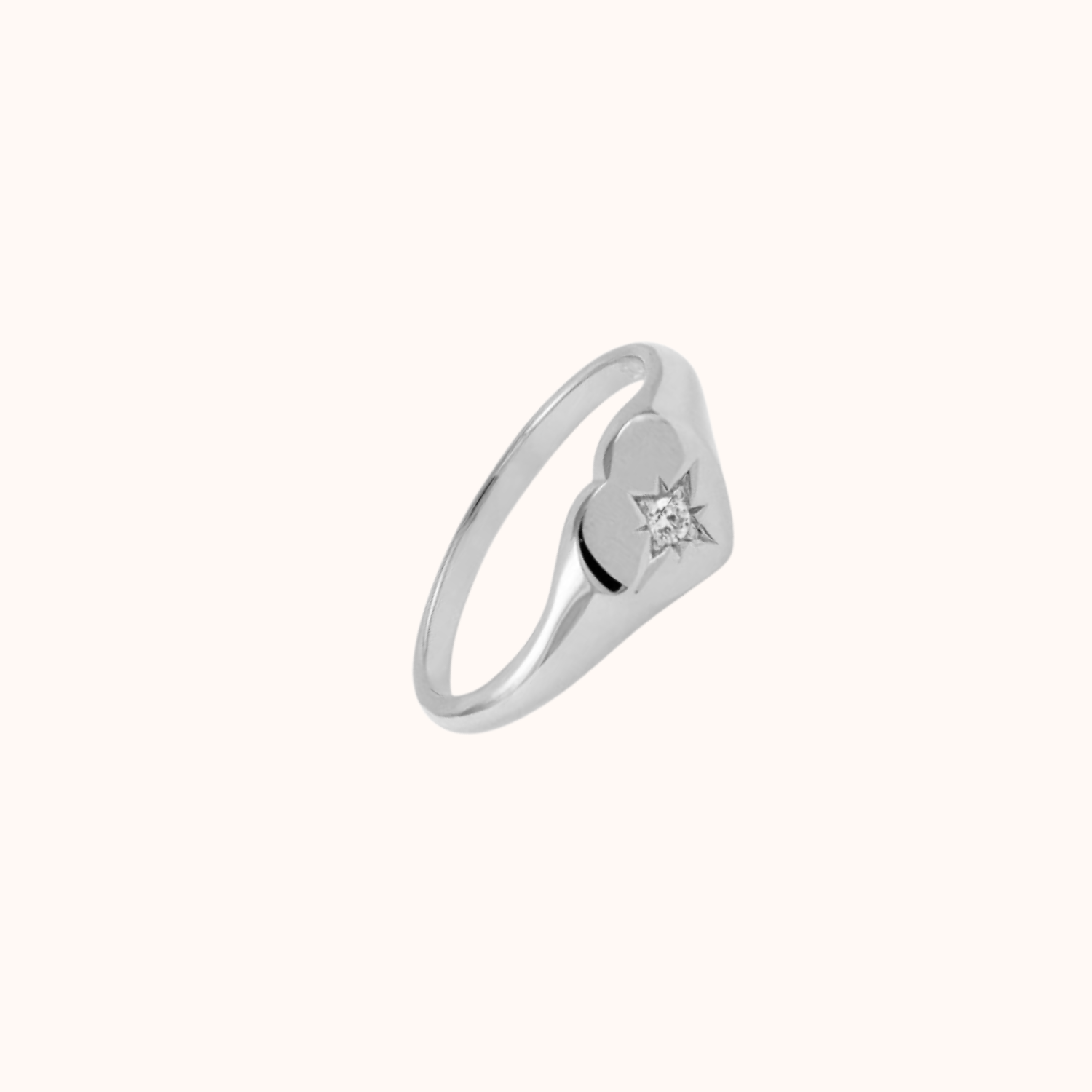 Silver heart signet ring on white background