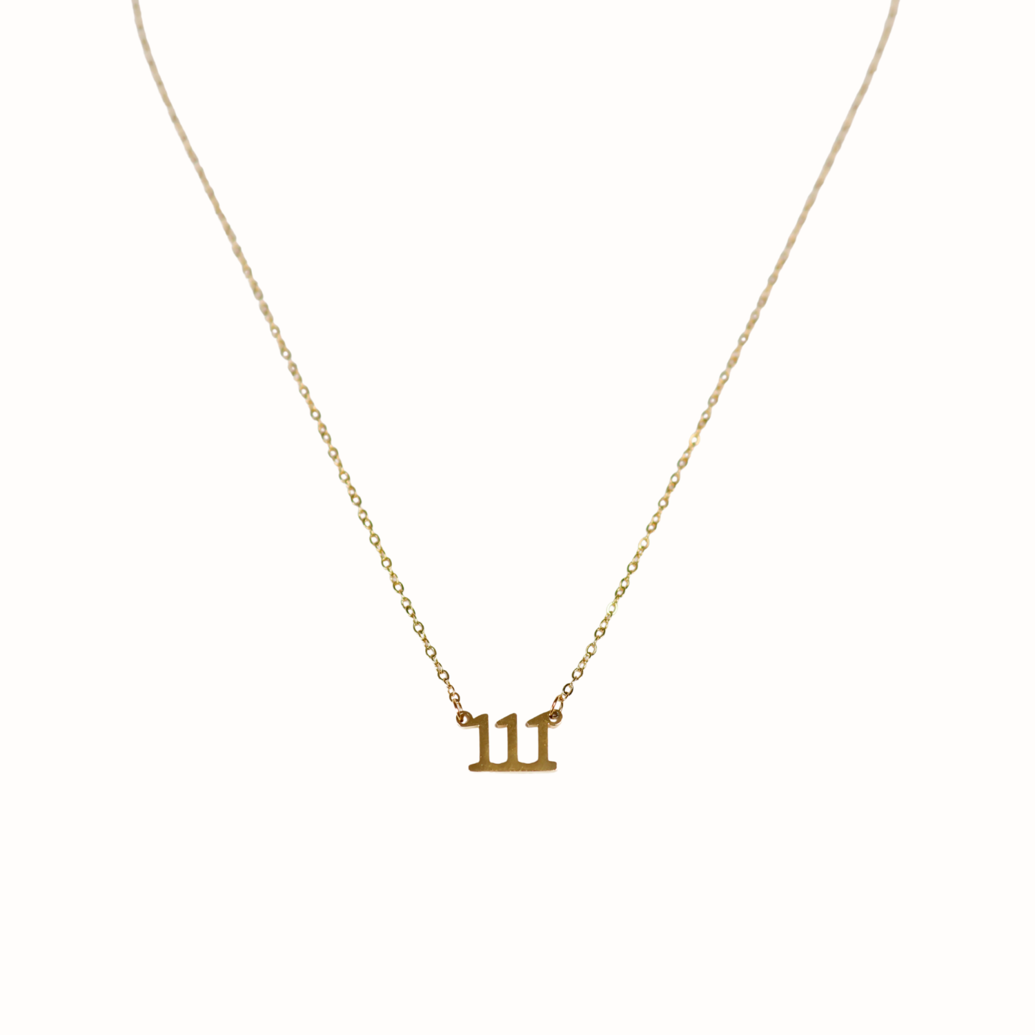 Gold necklace with a small triple one pendant on a white background